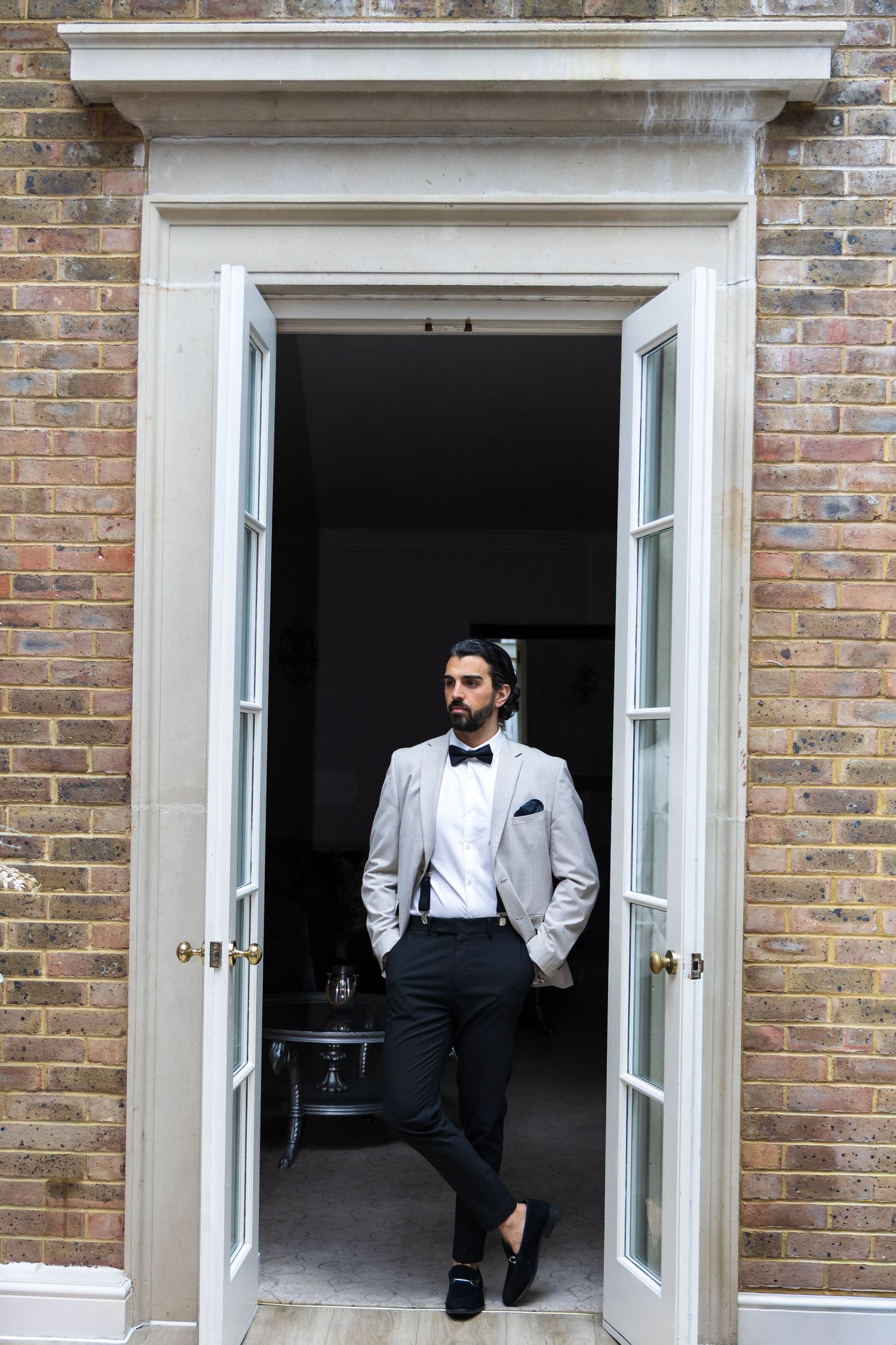 Groom standing in a doorway ready for his wedding day, de courceys manor