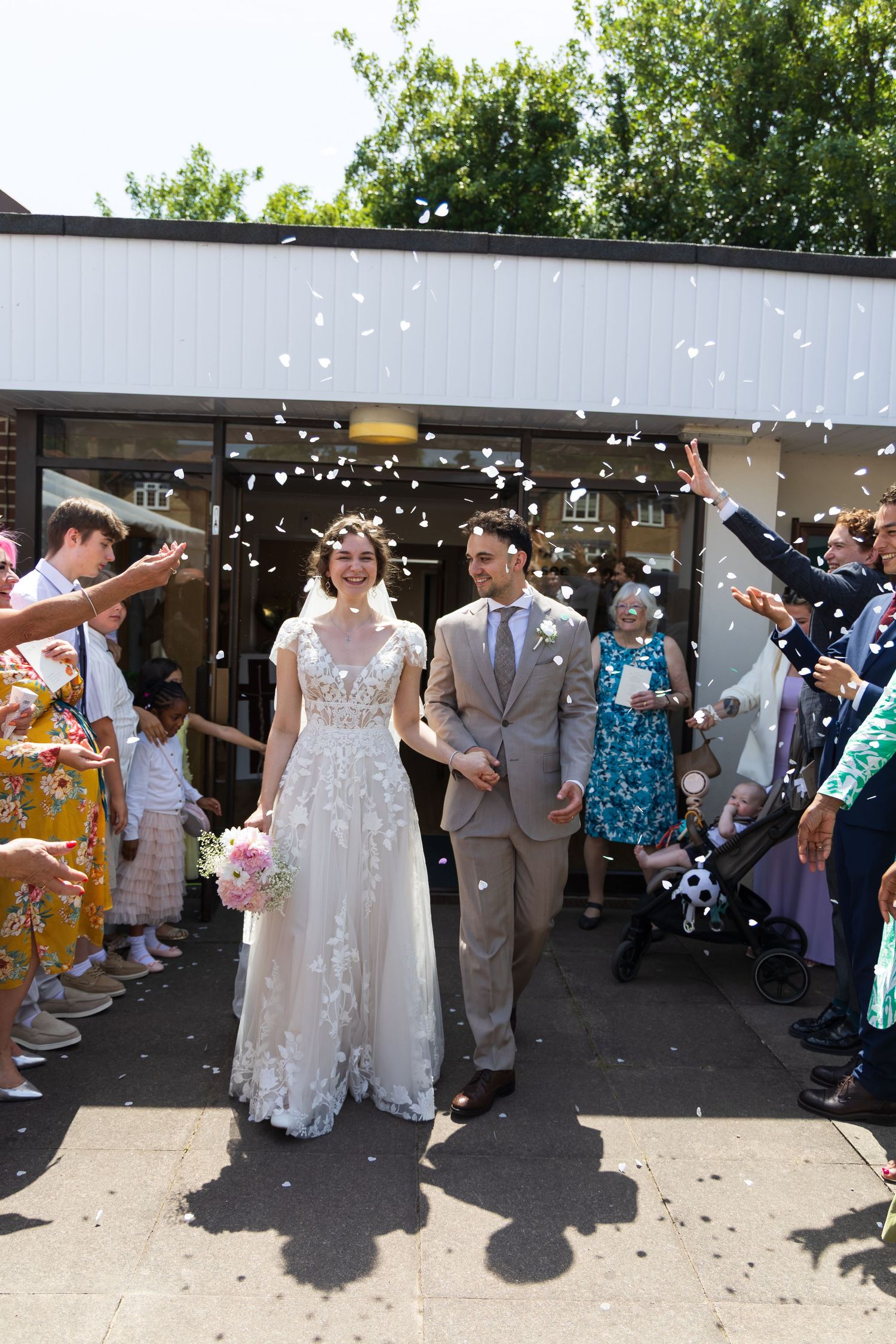 Wedding guests throwing confetti over the bride and groom