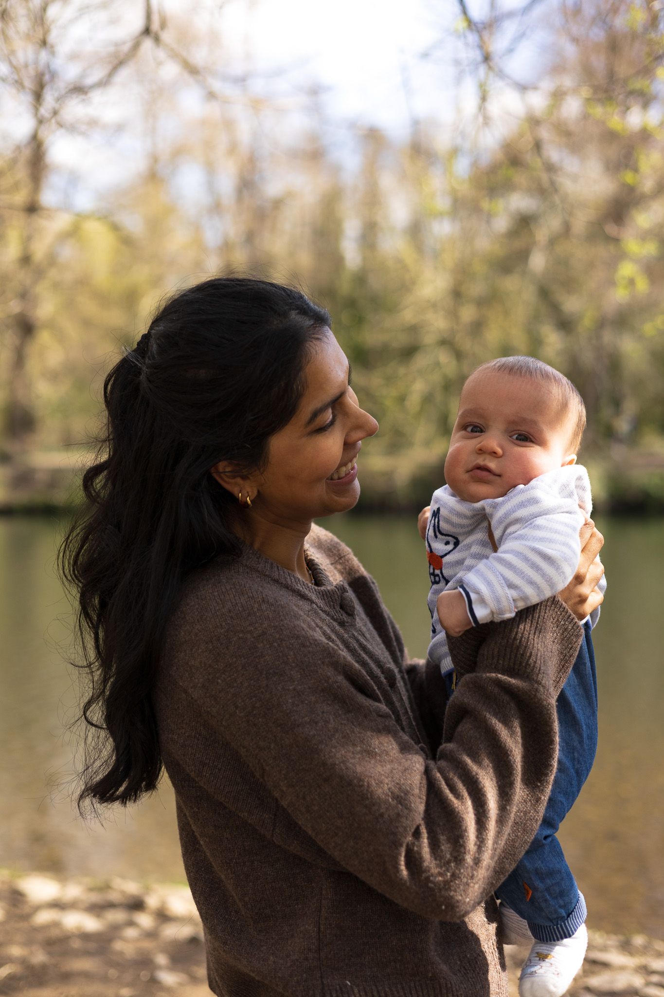Mother smiling at her baby in an autumn park