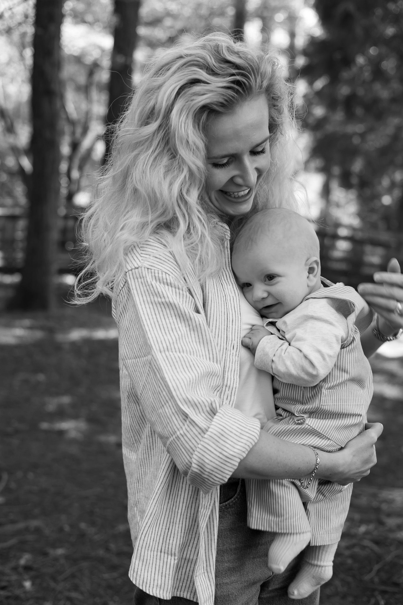 Black and white portrait of a mother holding her baby in the woods