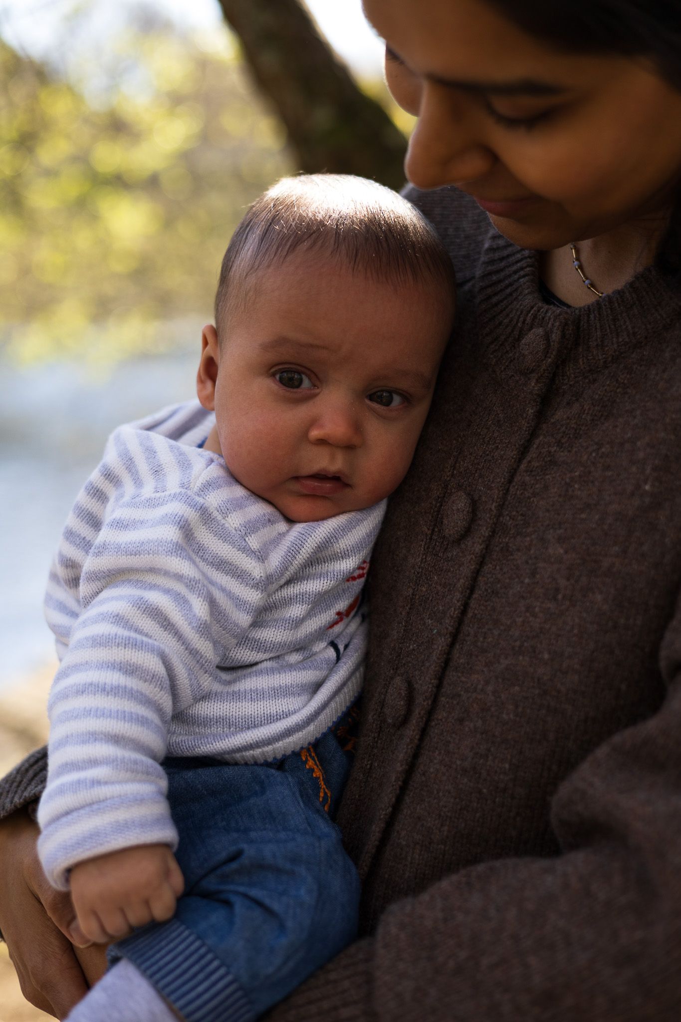 Parent holding baby outdoors during an autumn family photoshoot
