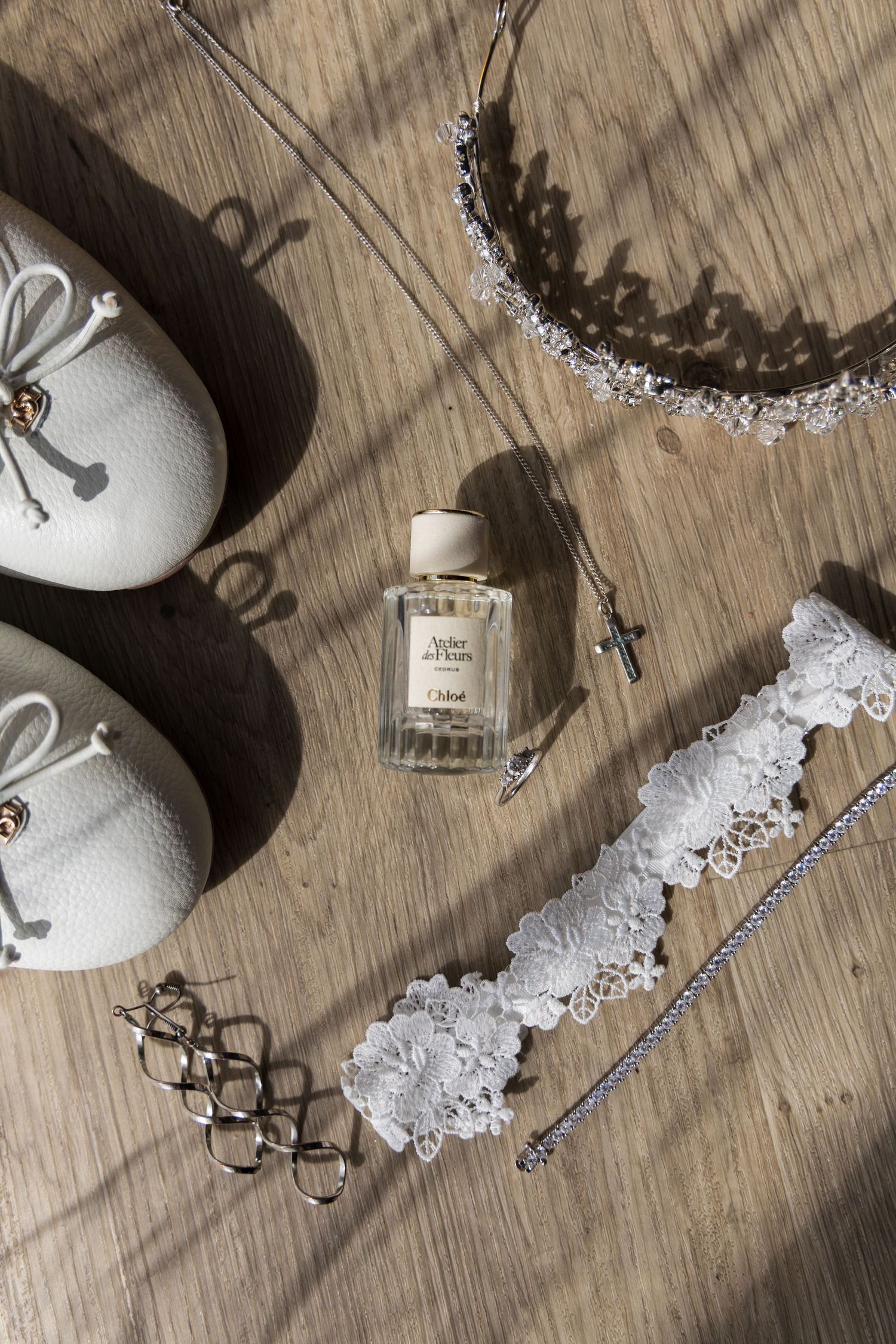 Flat lay of bride's wedding shoes and accessories on a wooden table