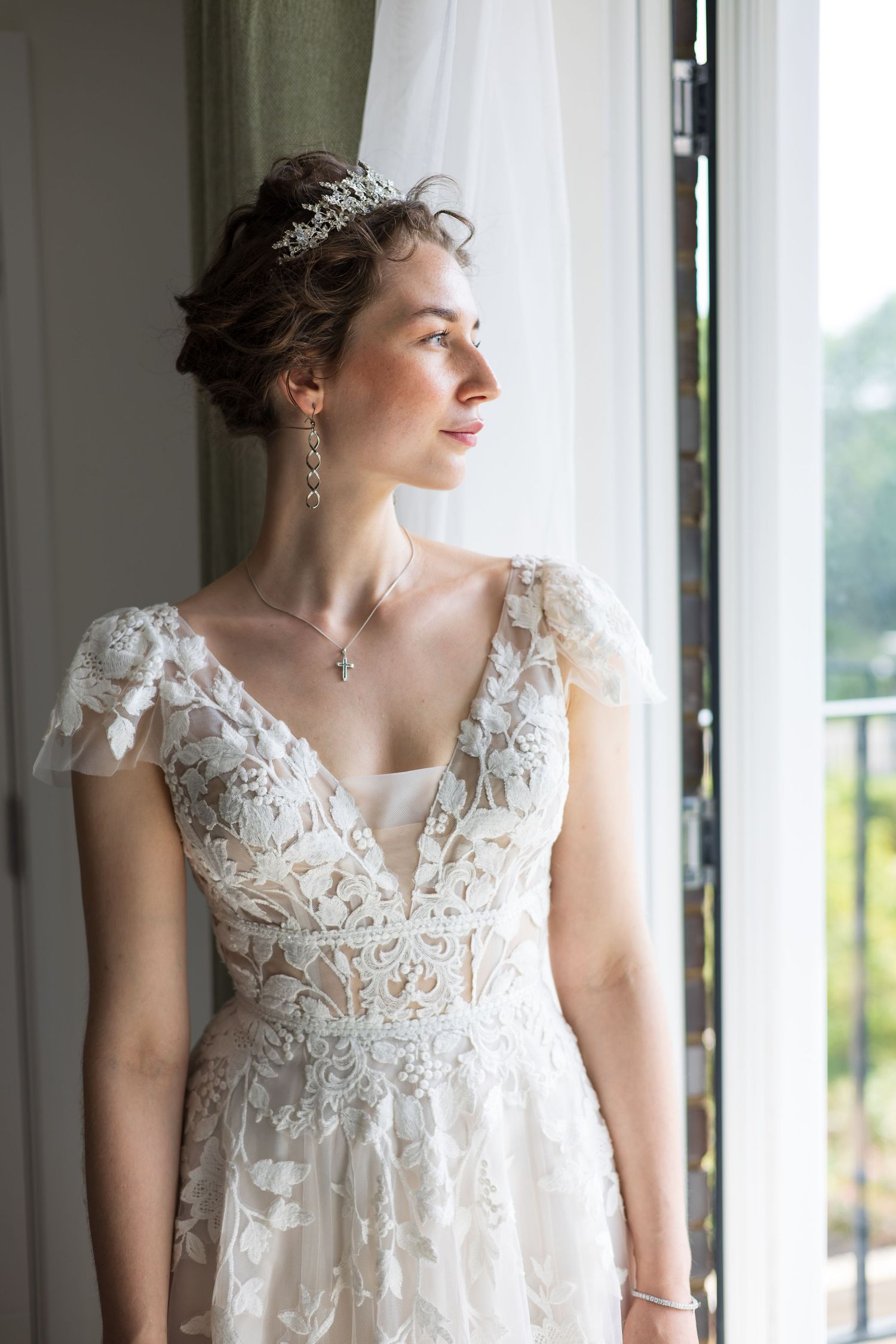 Bride looking out the window in her wedding dress