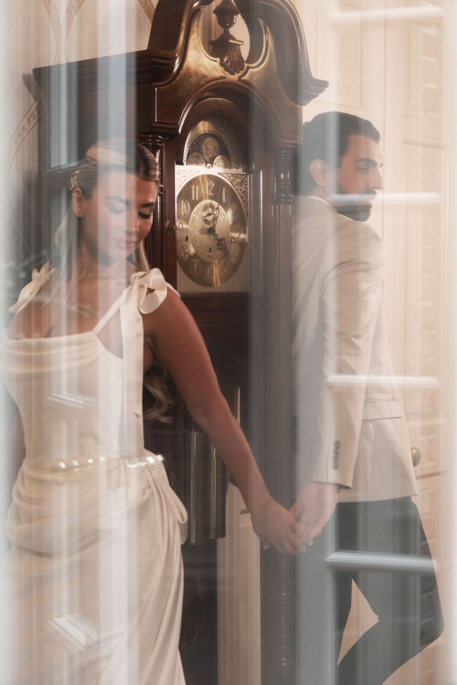 Bride and groom seen through a glass window reflection