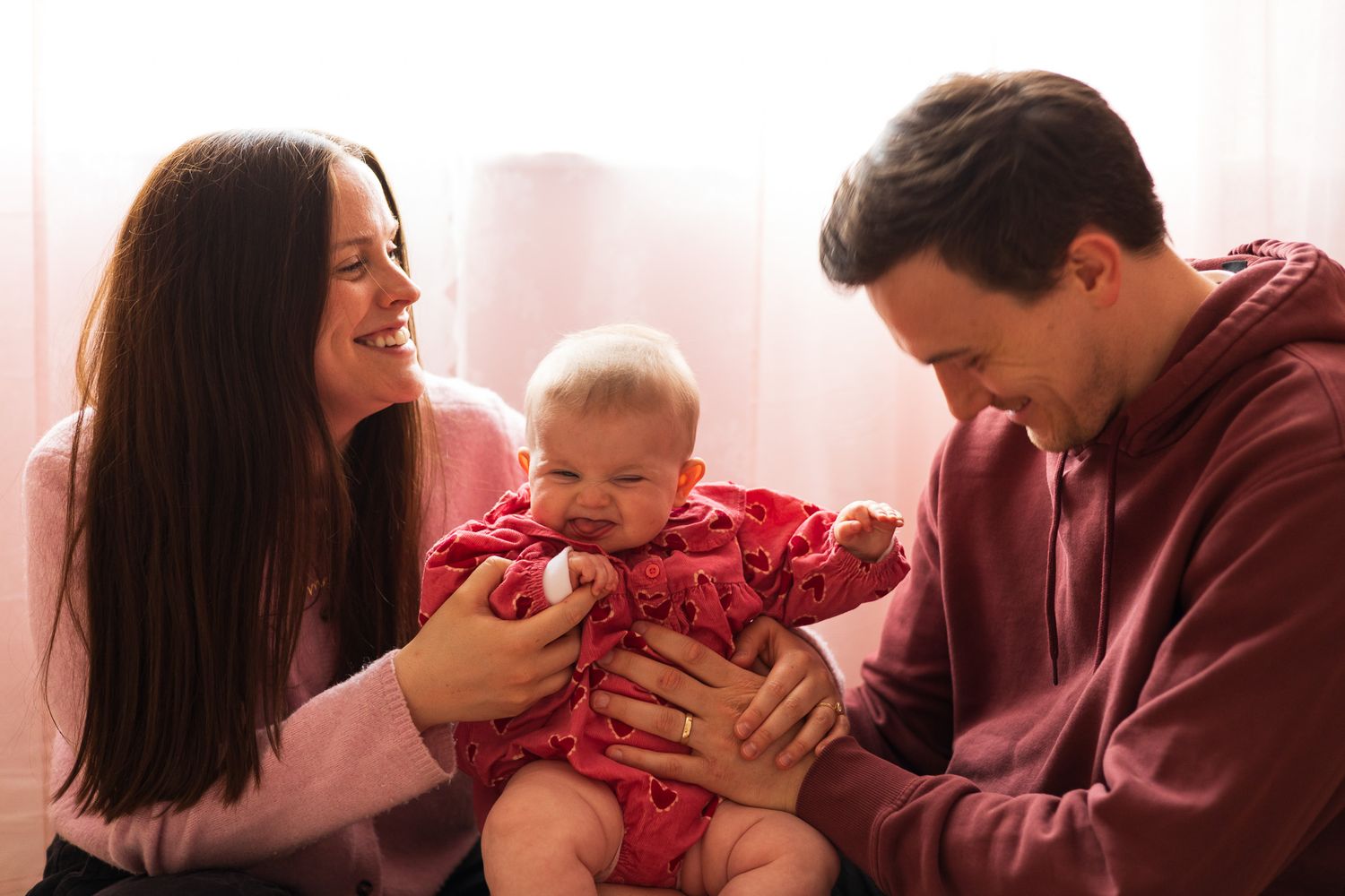 Parents smiling at their baby during a family photoshoot