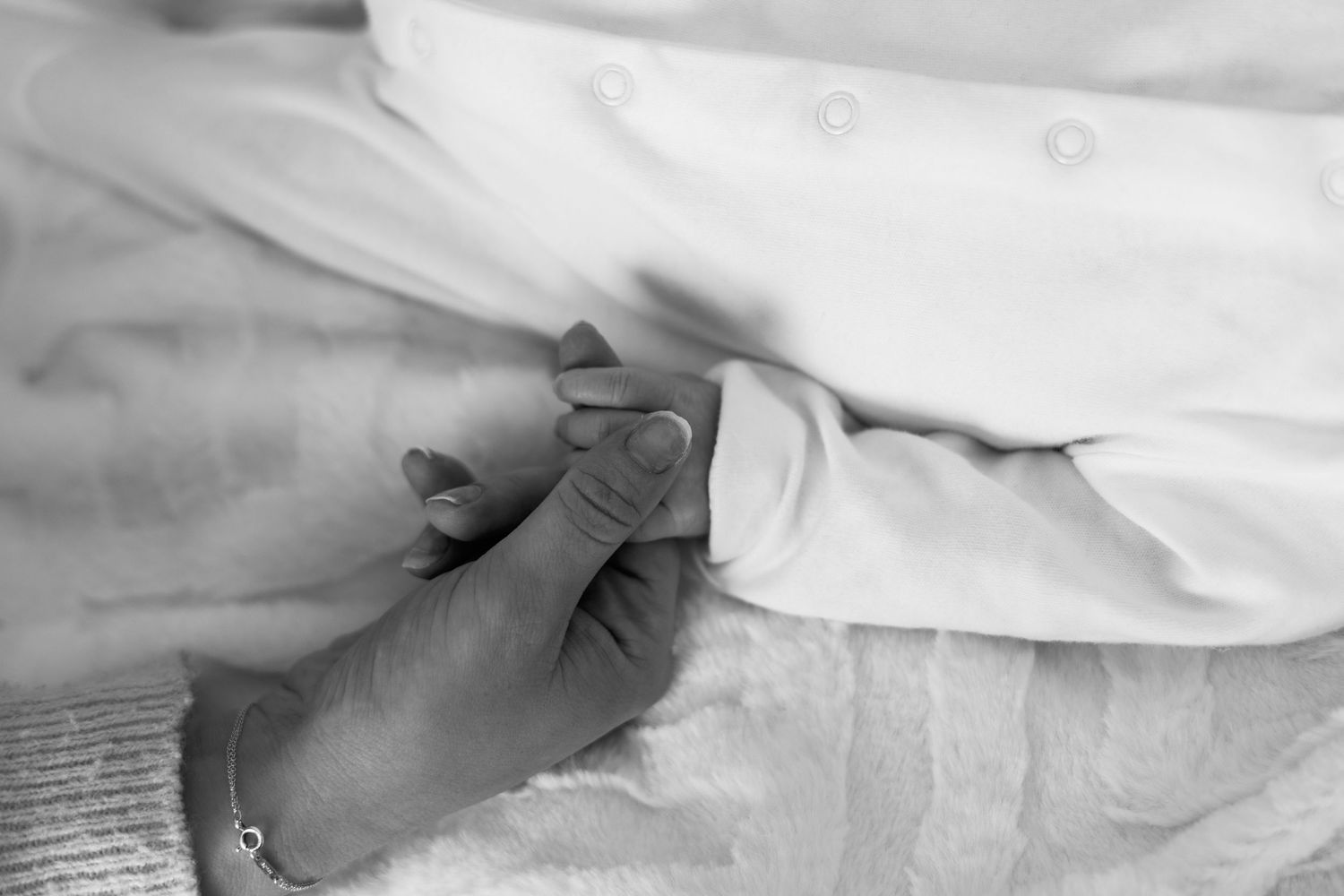 Black and white close-up of a newborn baby's hand
