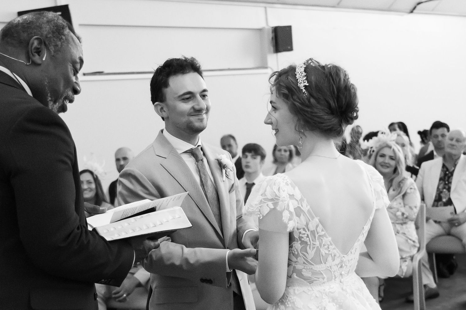 Black and white photo of groom receiving a card from a guest before the ceremony
