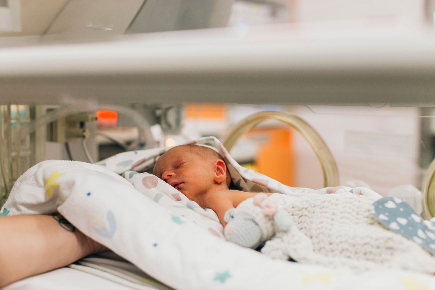 Newborn baby resting peacefully in a hospital incubator, wrapped in a soft blanket in the NICU.