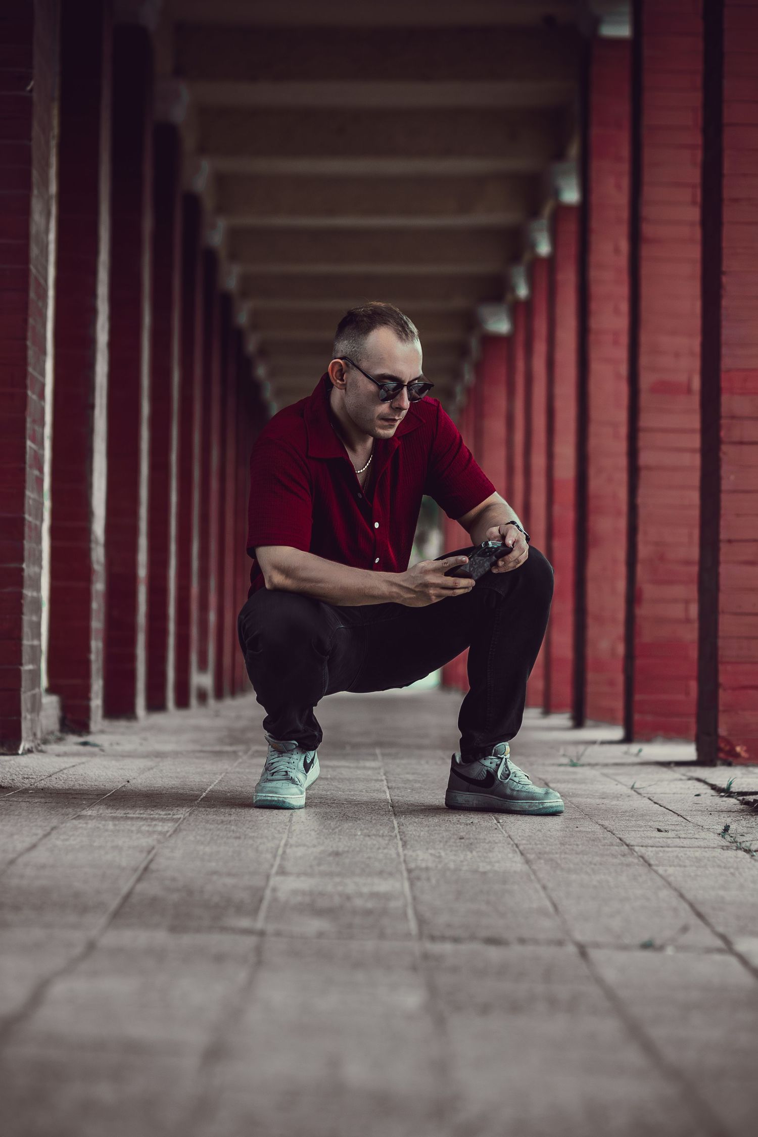 model v červenej košeli pri stĺpoch