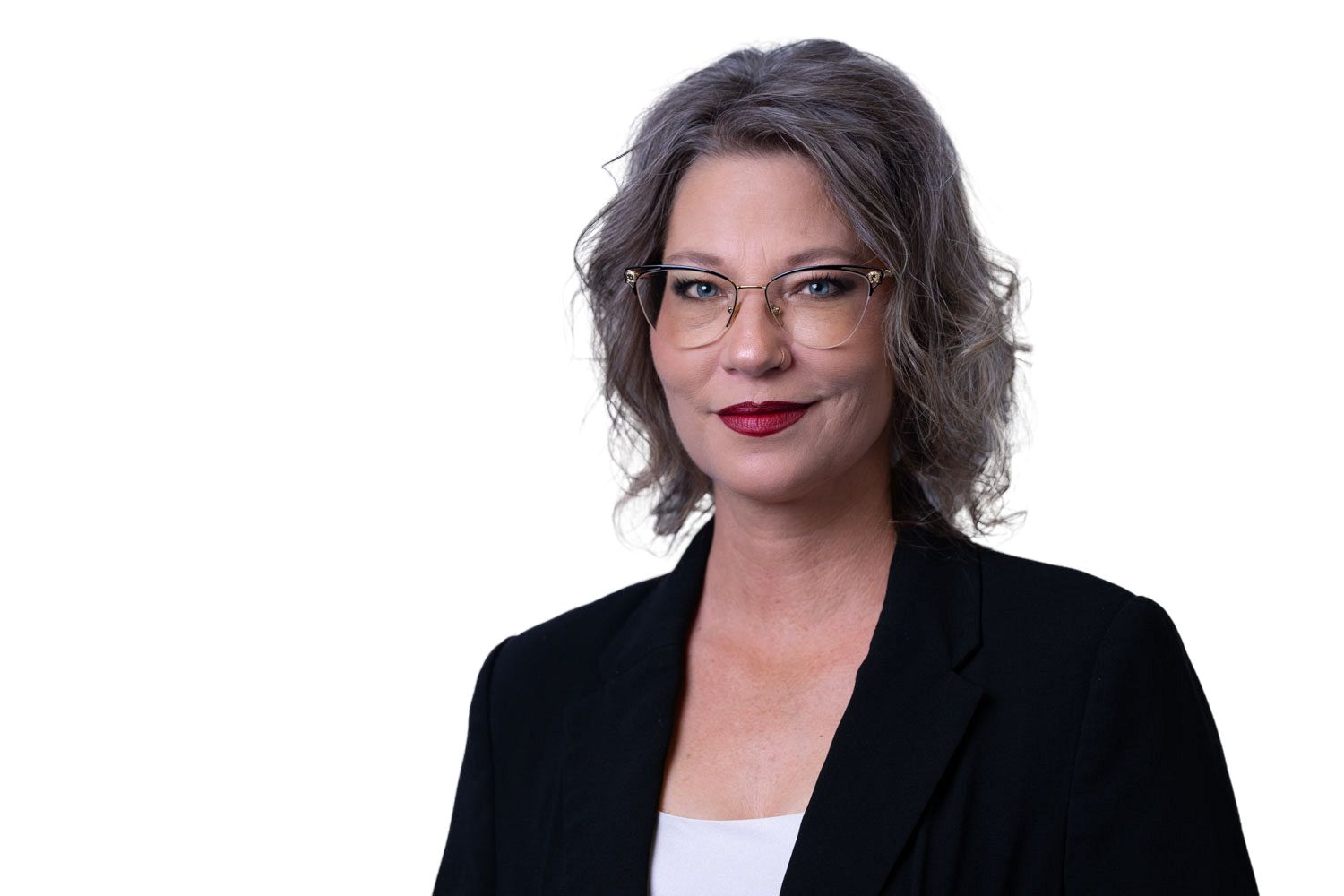 Professional woman with gray hair and glasses in black blazer against white background.