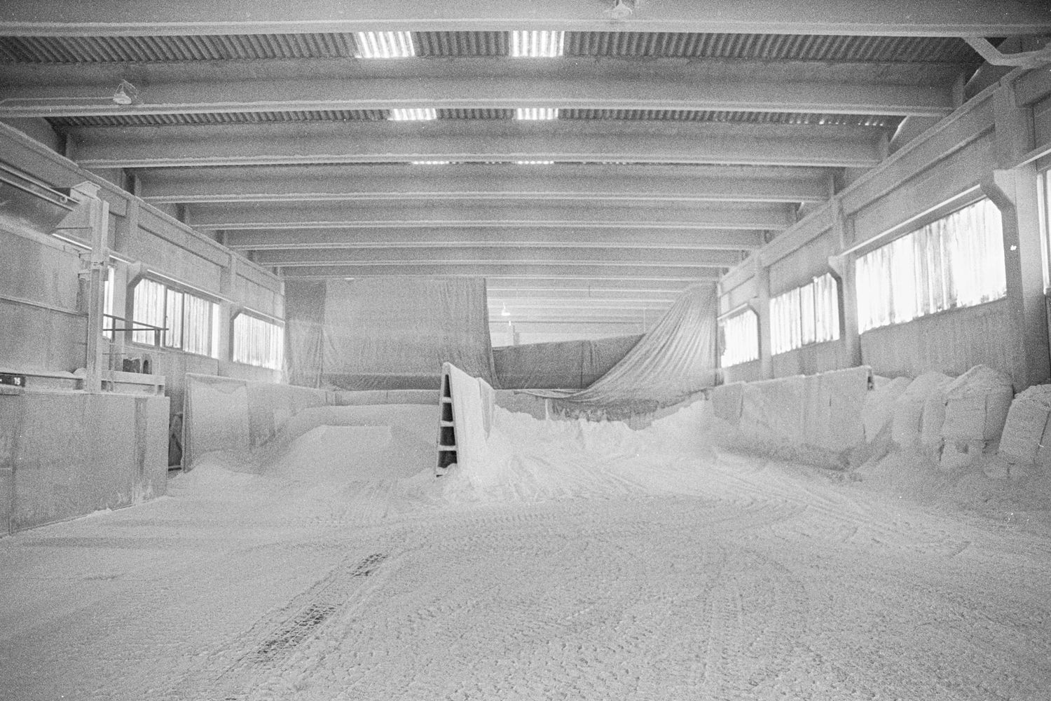 Lagerhalle eines Marmor Verarbeitenden Betriebes bei Carrara, Italien, mit einem Berg aus Marmormehl in einem Silo