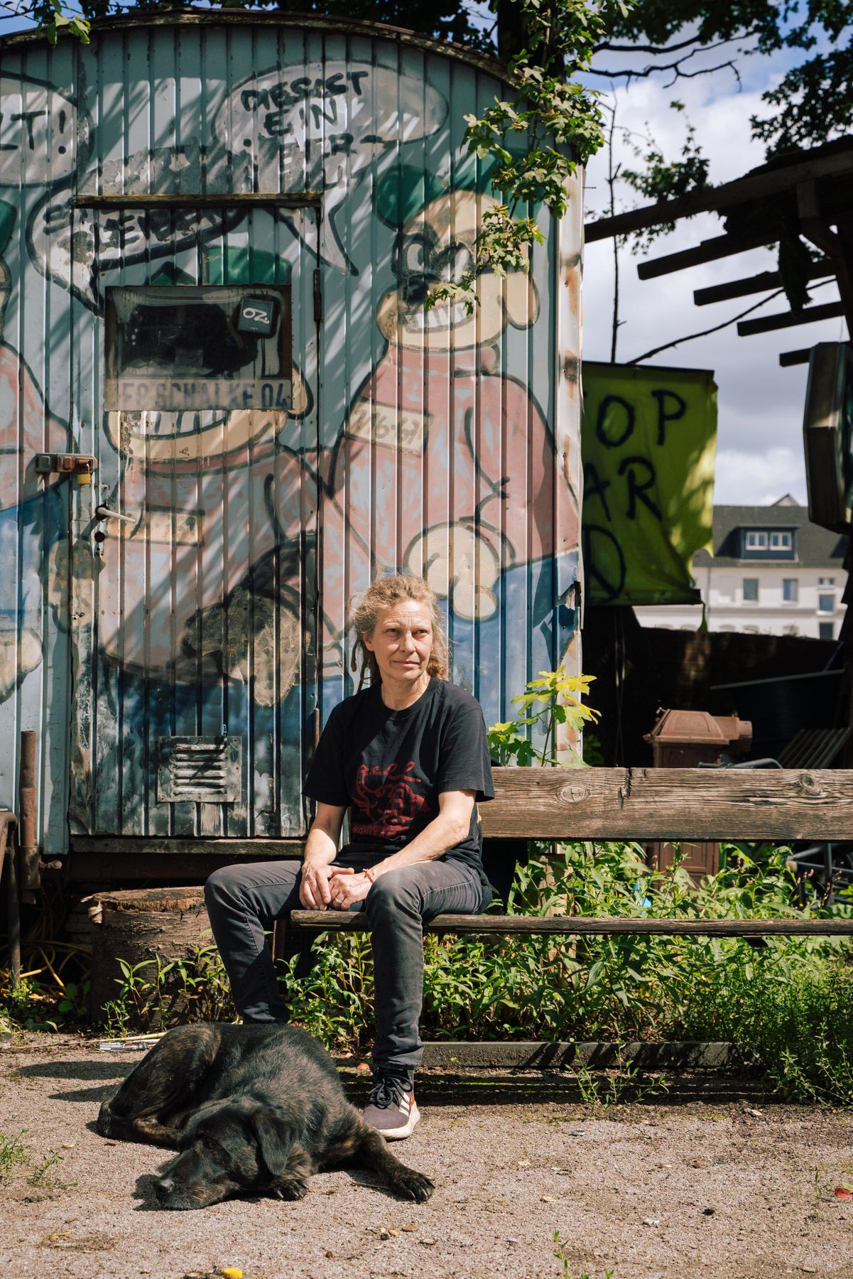 Portrait von Gabi M. mit ihrem Hund auf dem Bauwagebplatz in Hamburg, auf dem sie lebt