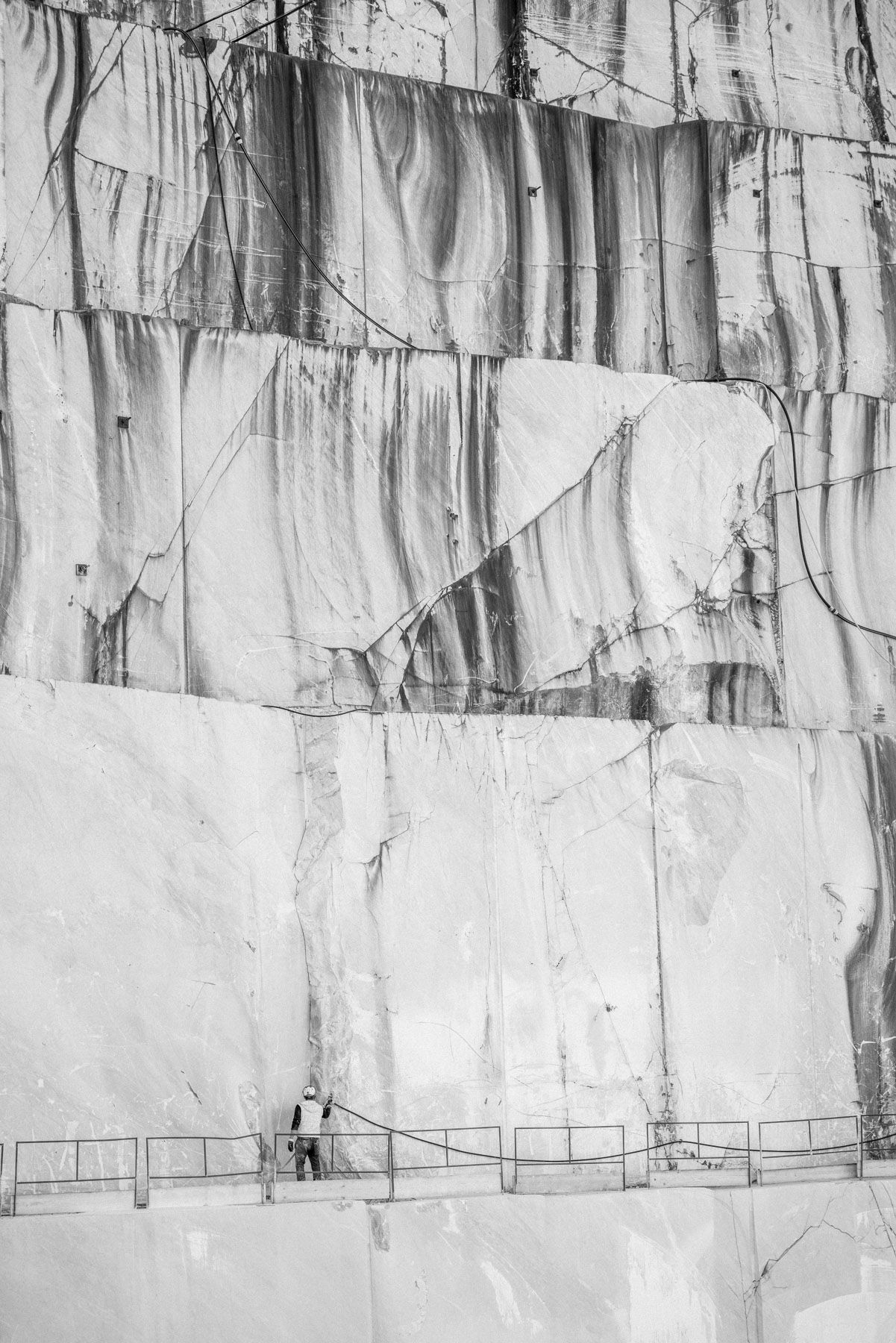 Übersicht einer Schlucht und einem Arbeiter in einem Marmorsteinbruch in Carrara, Italien