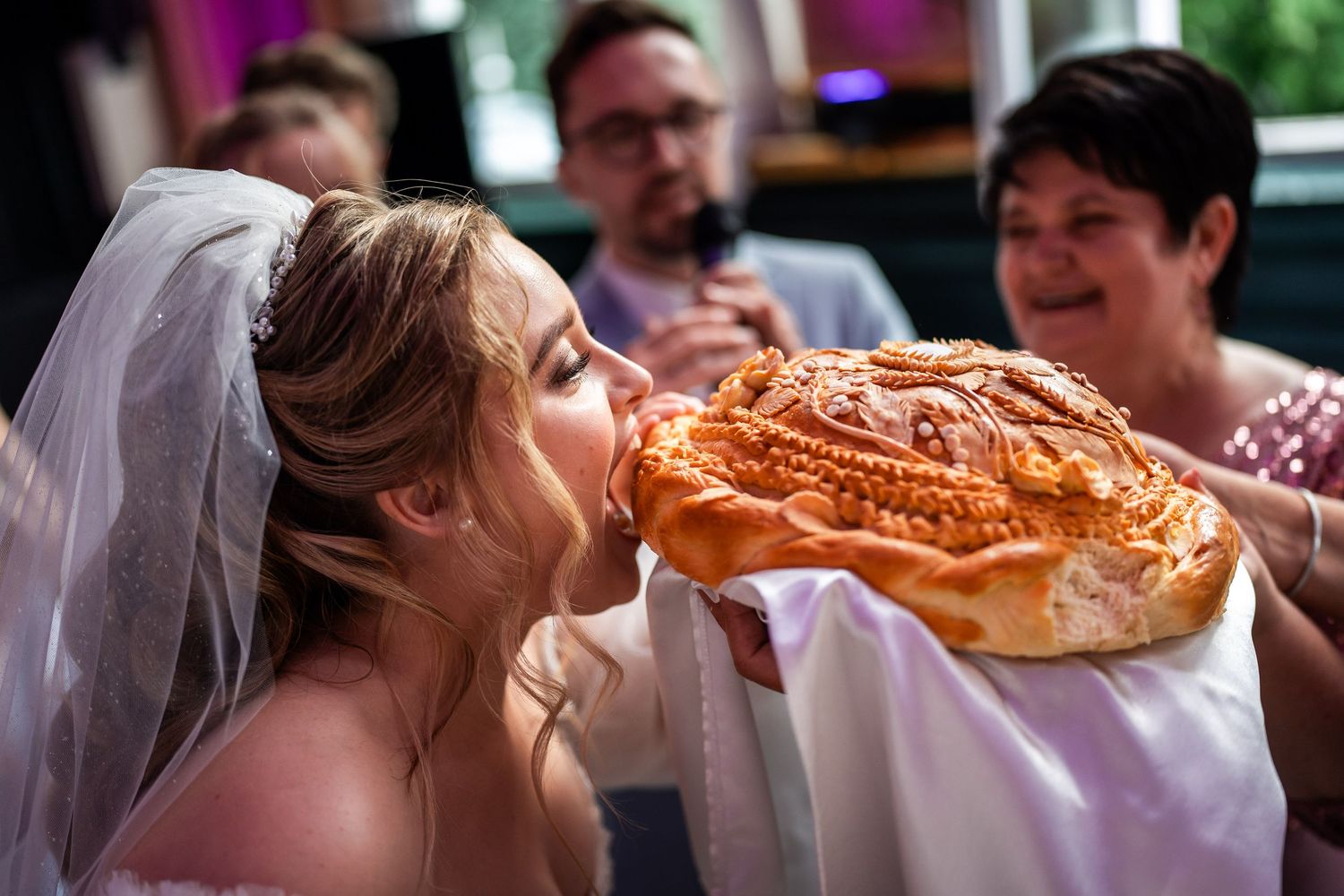 Die Braut beißt ein traditionelles russisches Hochzeitsbrot an