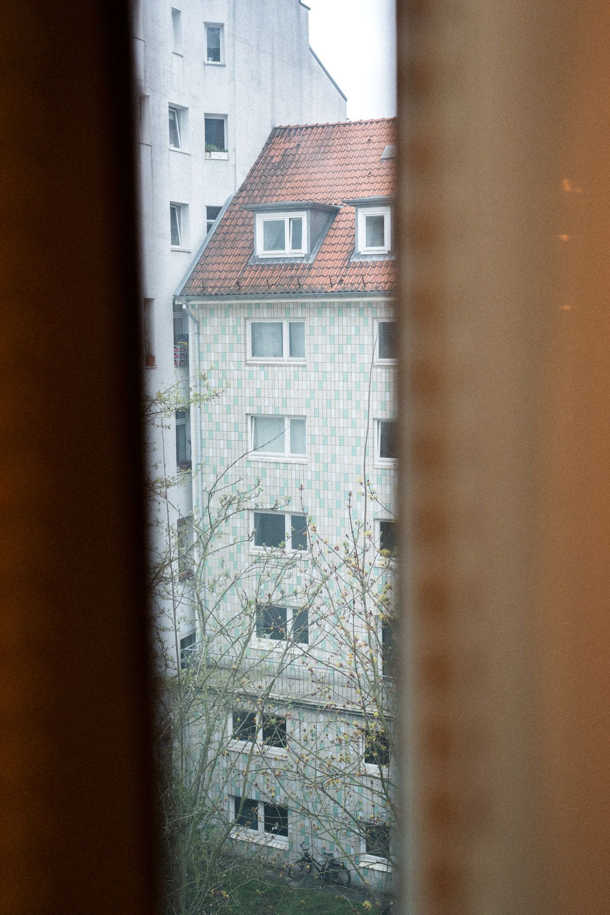 Blick aus dem Schminkzimmer in den kargen Innenhof von Christians Wohnung. Der Vorhang ist geschlossen.
