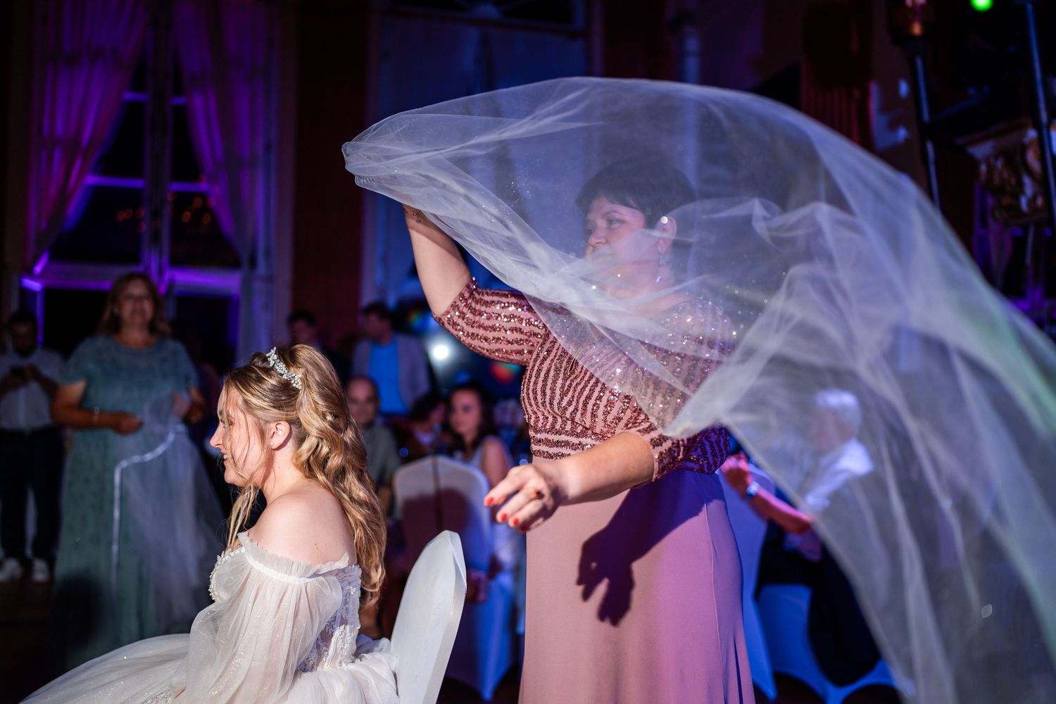 Die Schwiegermutter nimmt der Braut den Hochzeitsschleier ab