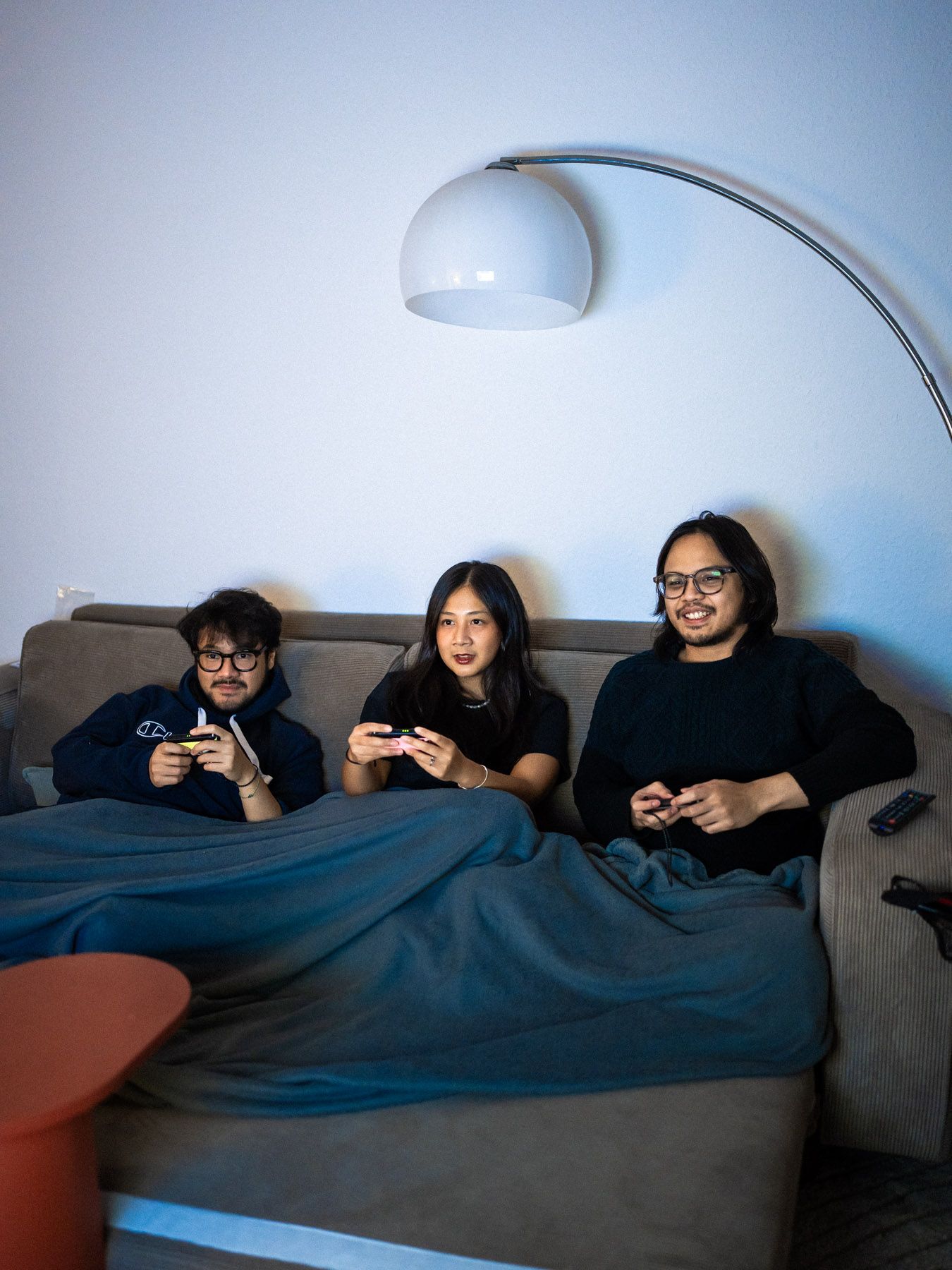 Nico sitzt mit seiner Schwester und ihrem Freund auf dem Sofa. Sie spielen Nintendo Switch.
