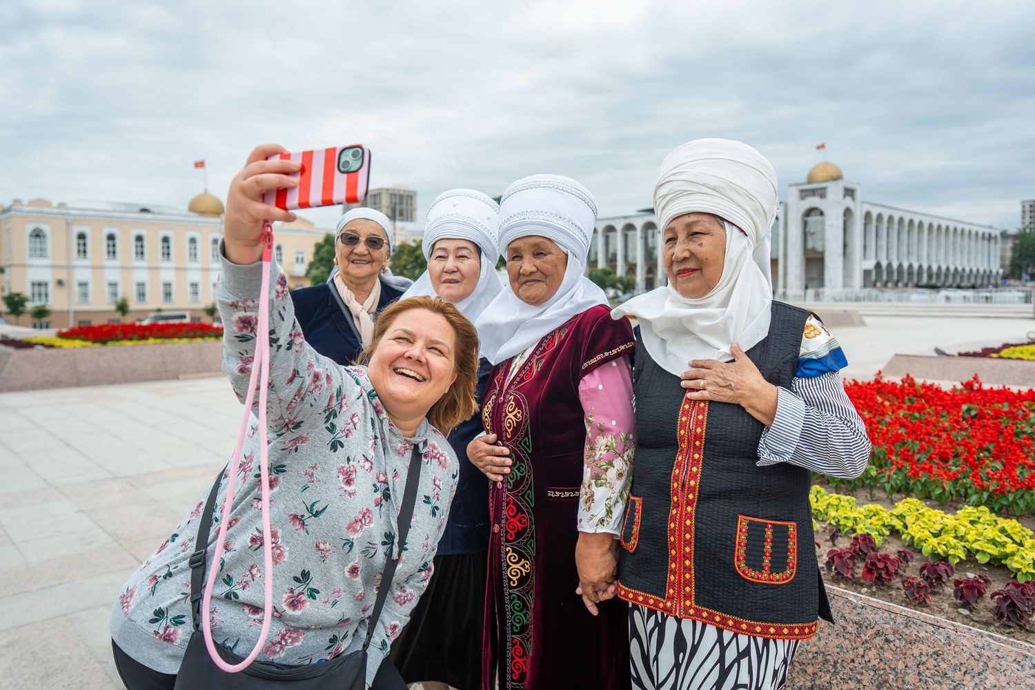 Eine deutsche Frau macht mit vier traditionell gekleideten Kirgisischen Frauen ein Selfie in der Hauptstadt Bishkek.