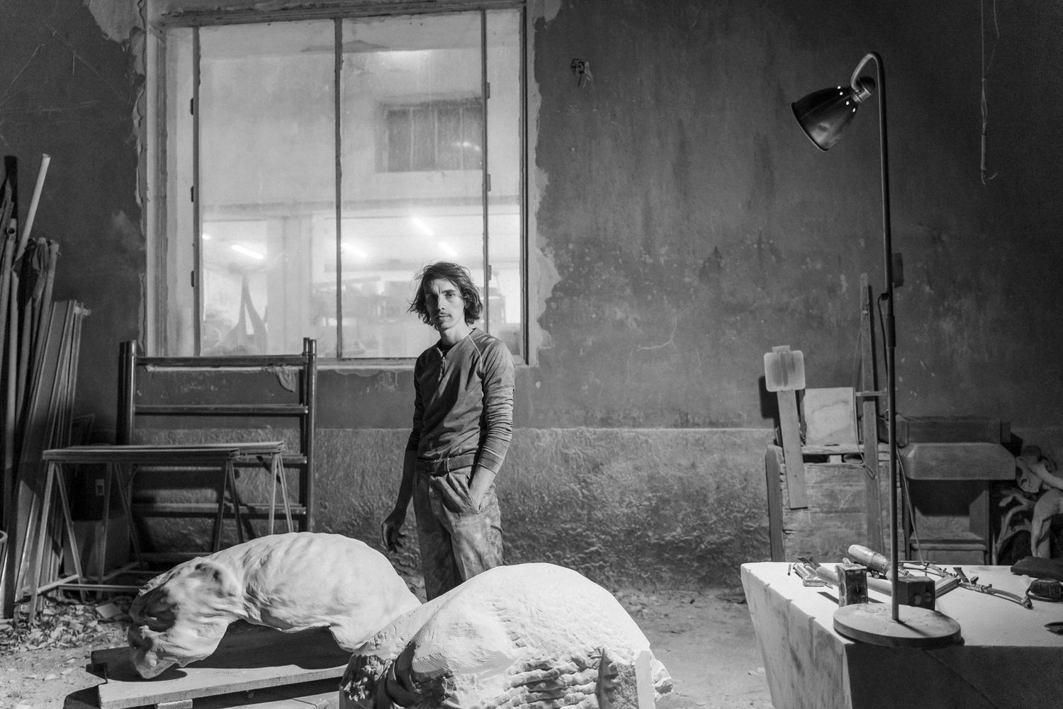 Portrait von Künstler Pierre Auzias mit Zigarette vor seinem Kunstwerk und dem dazugehörigen Gipsmodell ins Atelier Ponte di Ferro, Carrara
