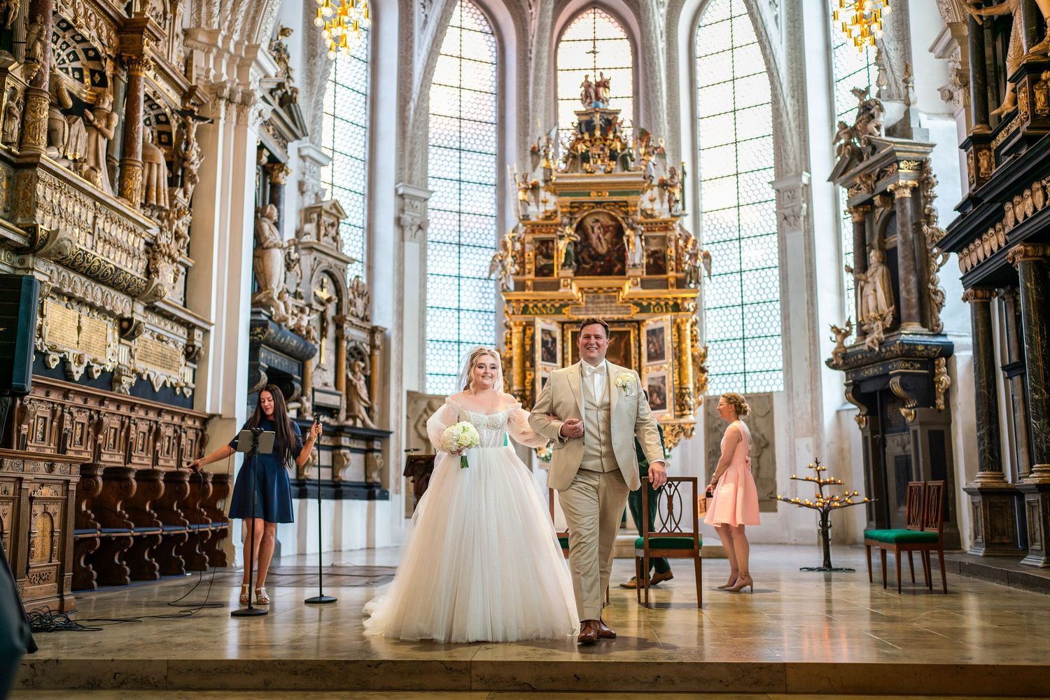 Das Brautpaar steht vor dem Altar in der Stadtkirche Celle und hält sich an den Händen