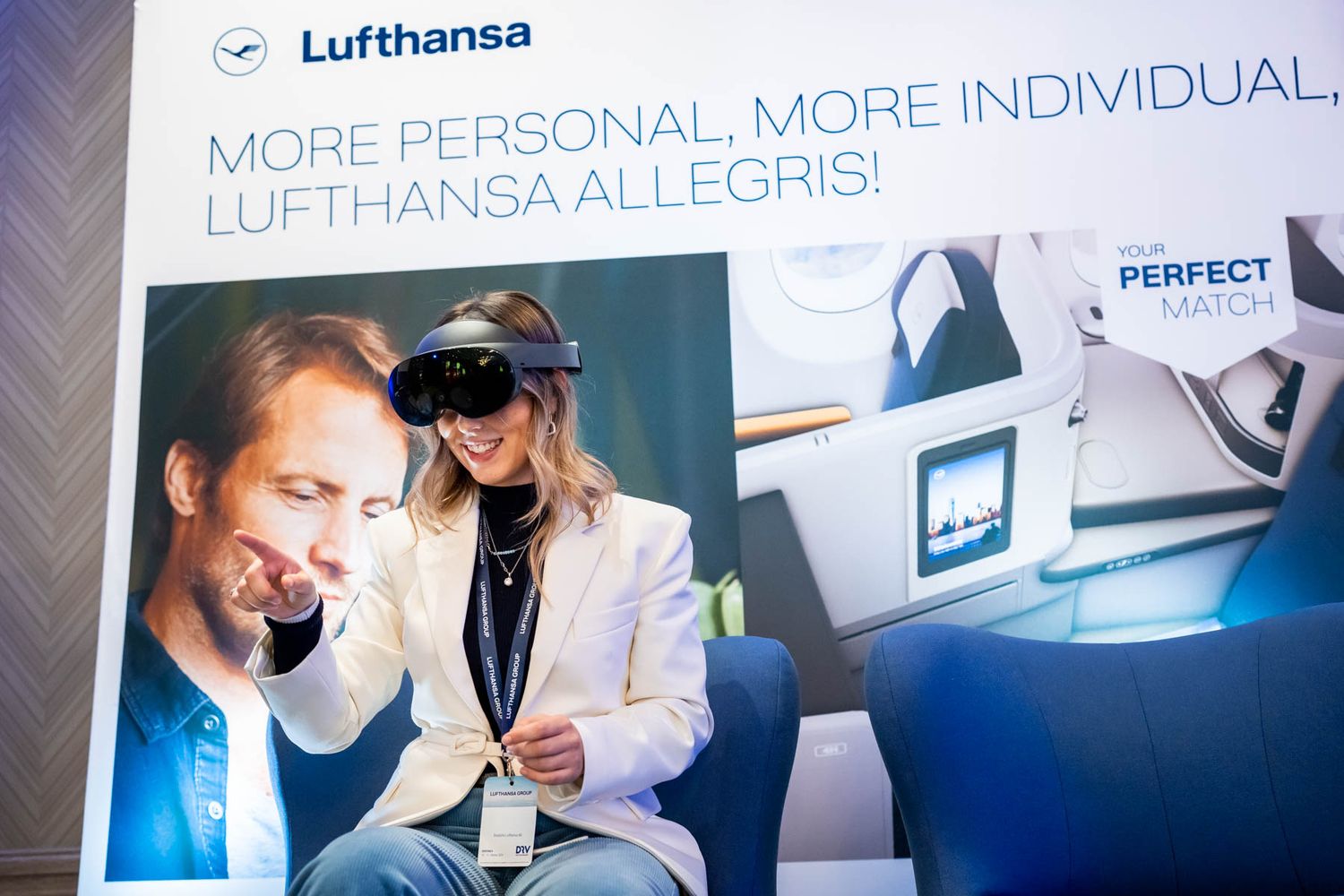 Eine Frau mit VR Brille sitzt an einem Stand des Sponsors Lufthansa auf dem Hauptstadtkongrass des DRV und erlebt das neue 