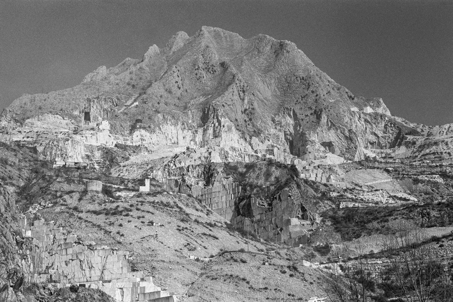 Übersicht eines grauen Berges mit gut sichtbaren weißen Marmor Steinbrüchen im Frantiscritti Tal in Carrara, Italien