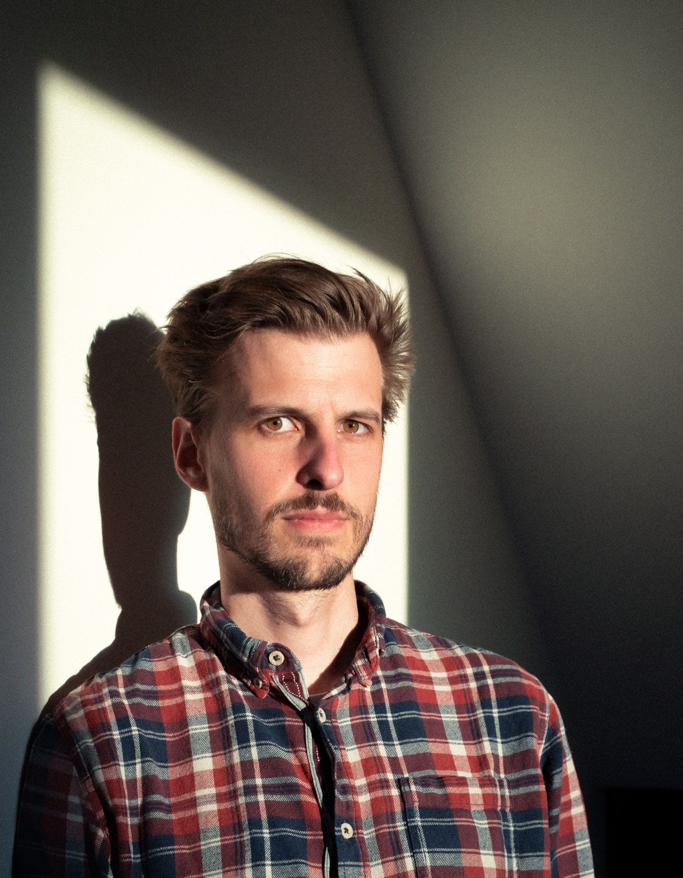 Portrait von Quantenforscher Fabian Wolf im Sonnenlicht durch ein Fenster in der  ITB Braunschweig