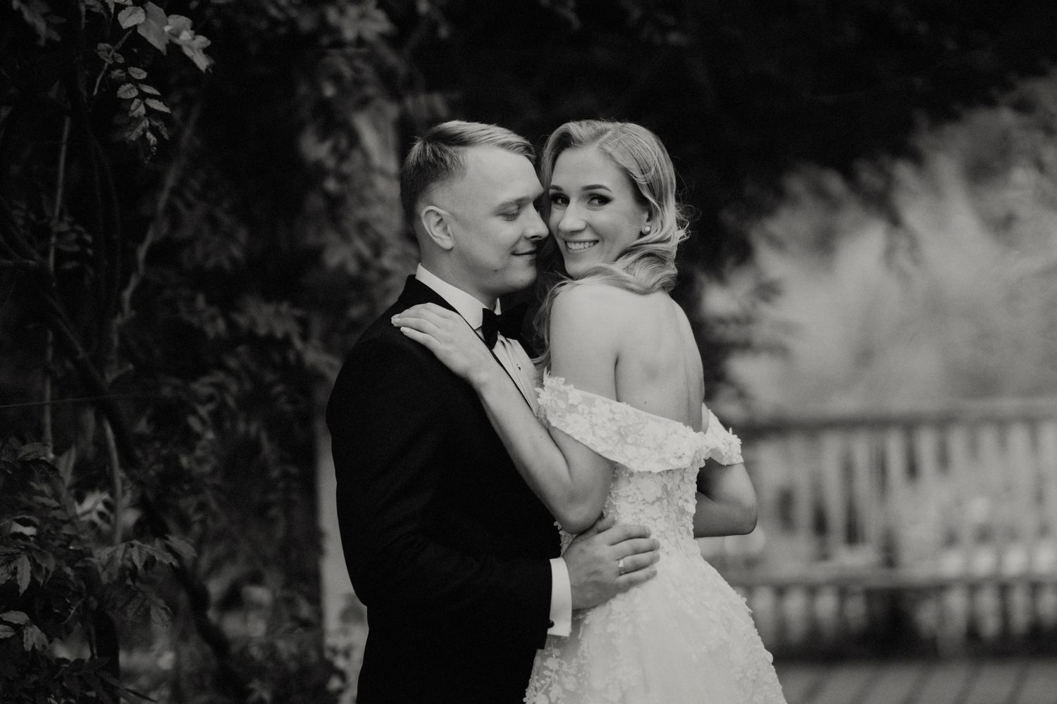 Black and white wedding photography sequence showing romantic poses against natural backdrop.