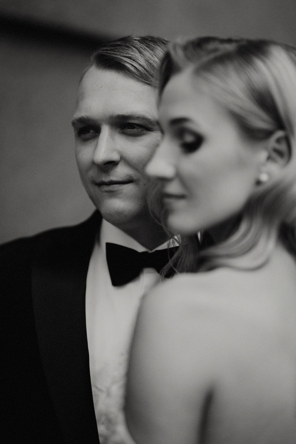 Romantic black and white close-up wedding portrait showing tender intimate moment between newlyweds.