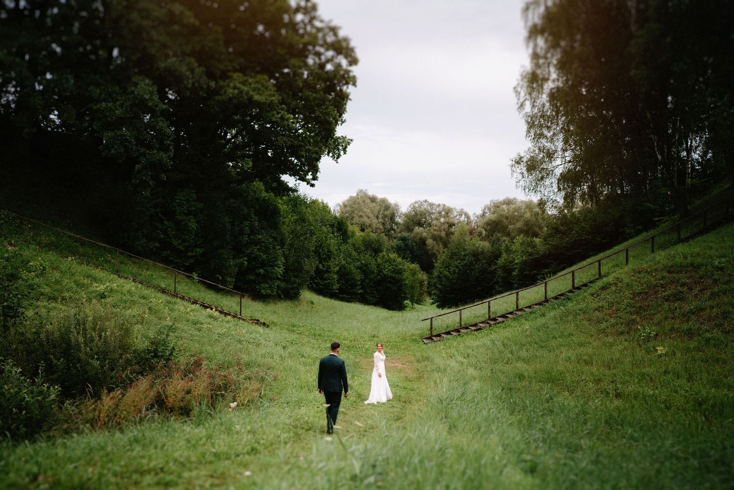 Panoramic wedding photography sequence in a rolling green landscape.