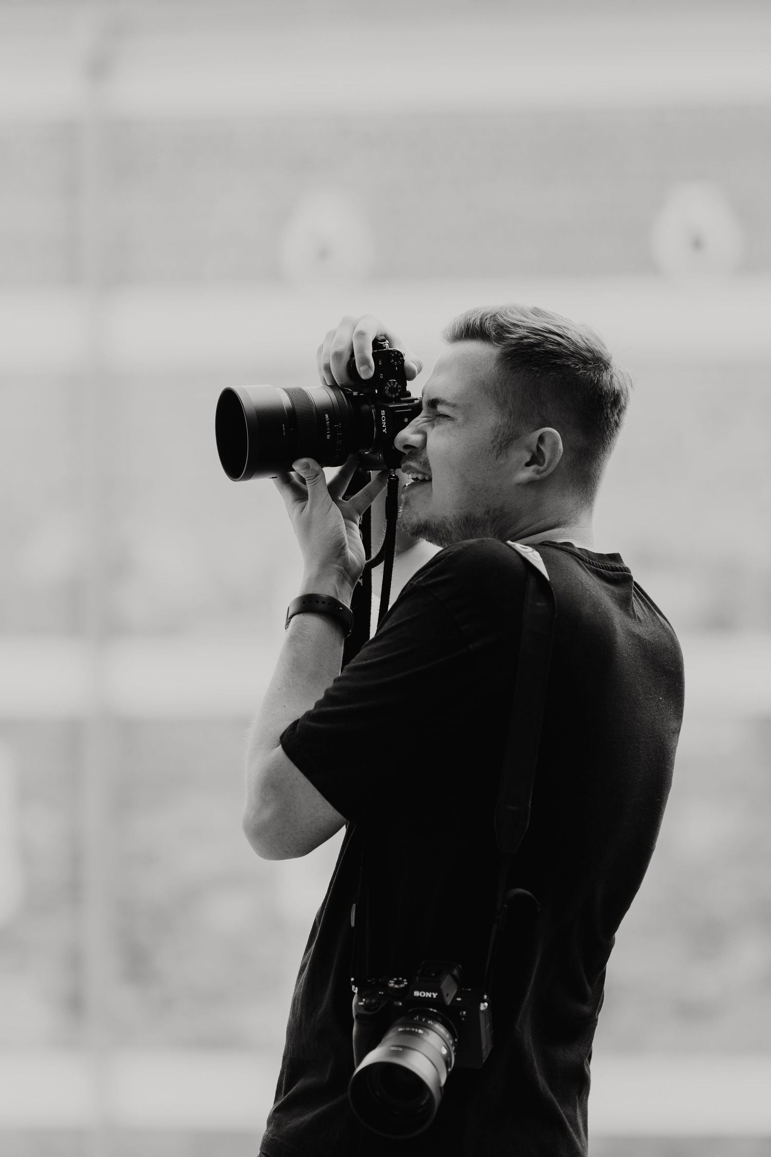 Black and white image of photographers with cameras in silhouette.