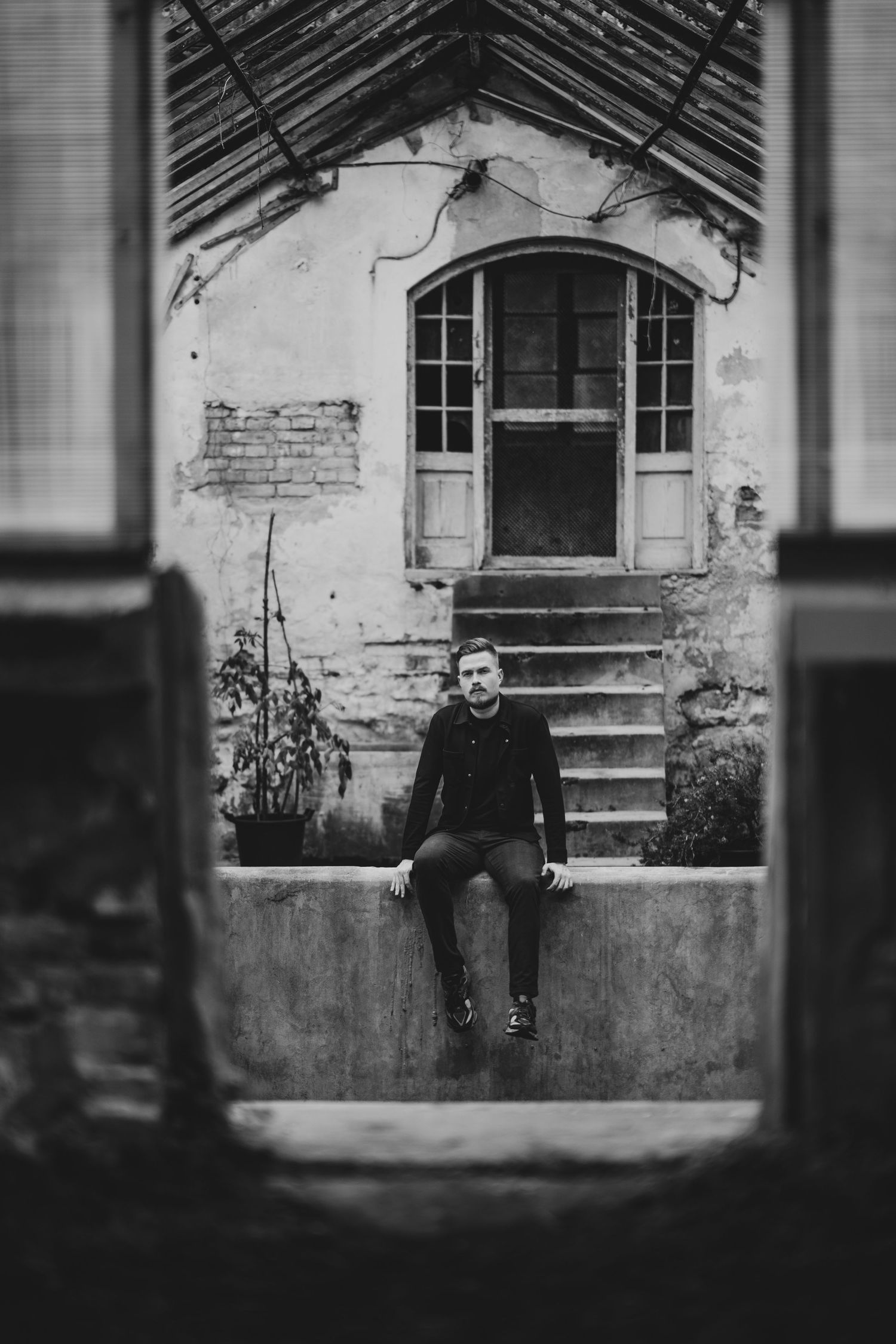 Artistic black and white photo captured through window frame of old building.