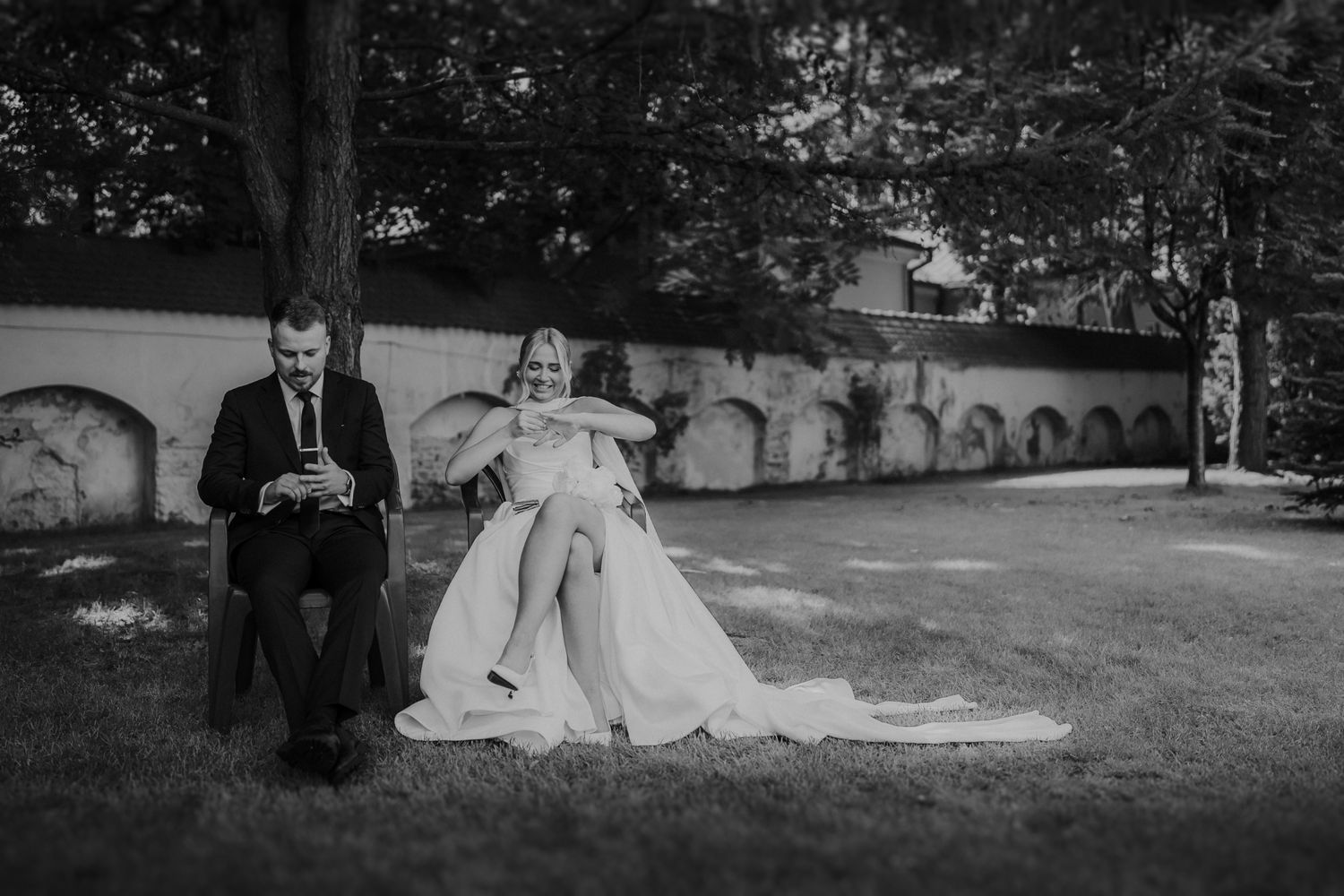 A panoramic black and white wedding scene with architectural elements and natural landscape.