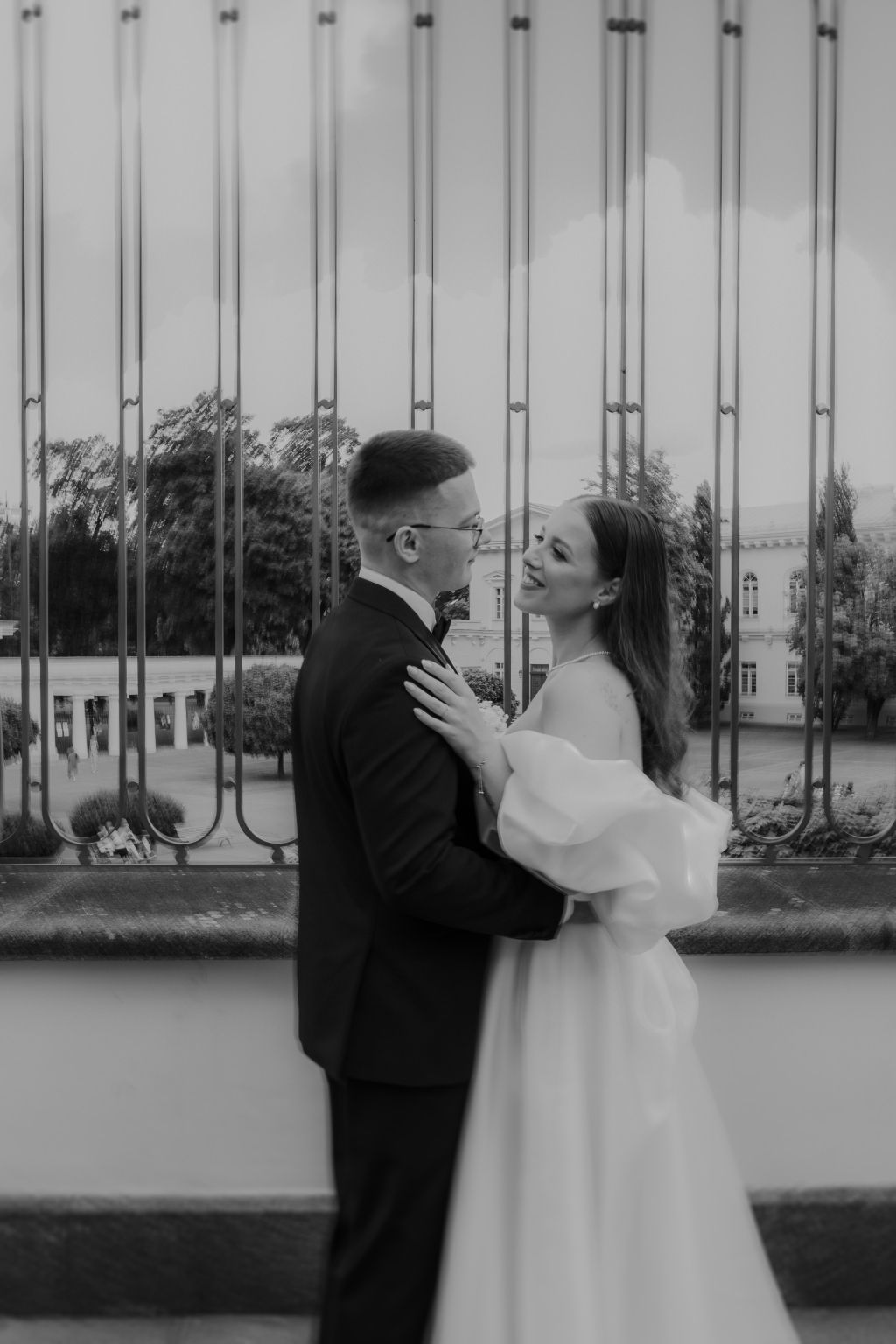A romantic black and white wedding sequence showing a couple embracing against an architectural backdrop.