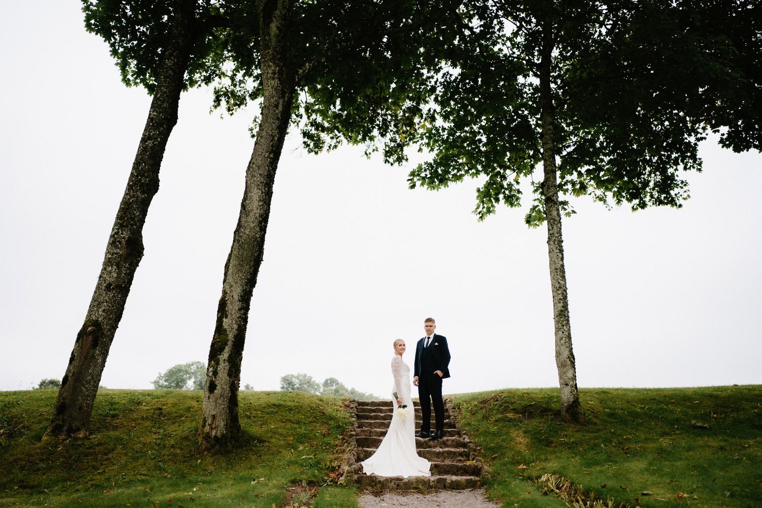 Wedding ceremony setup with trees framing a hilltop landscape.