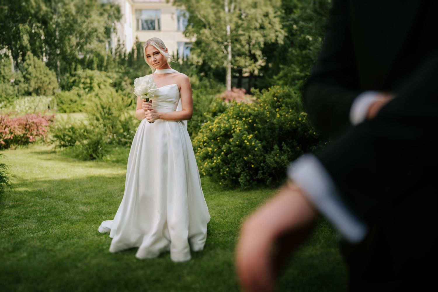 Wedding couple walking through a lush garden setting on their special day.