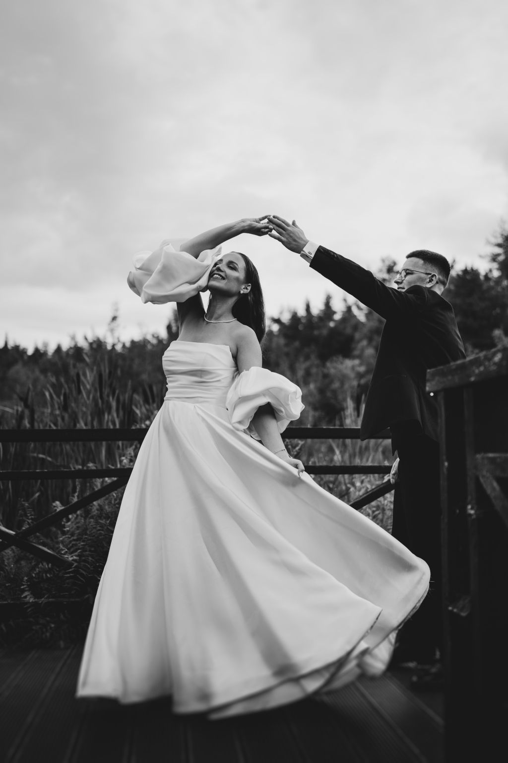 A dramatic black and white sequence of a bride twirling in her flowing wedding dress.