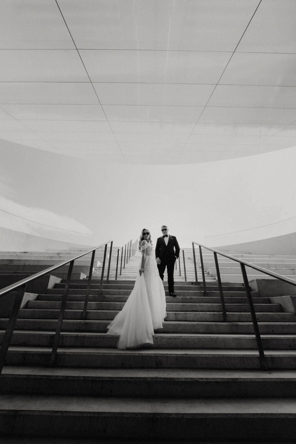 Minimalist black and white wedding photo on geometric steps with clean lines and shadows.