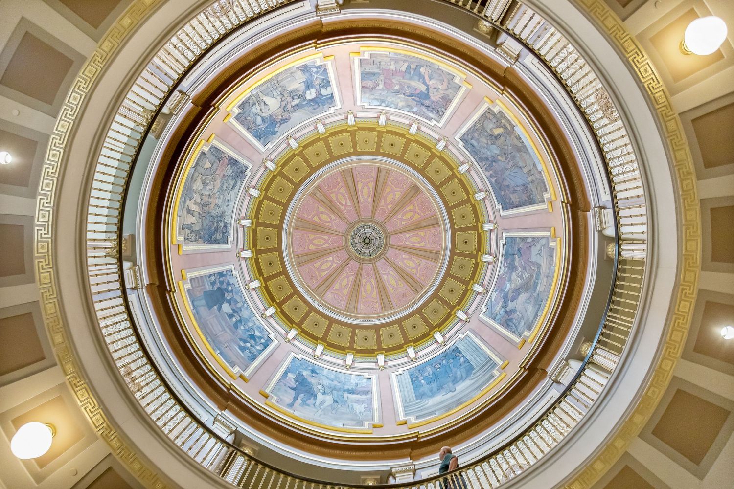 Ornate circular rotunda dome with pastel blue and gold architectural details painted on the ceiling interior.