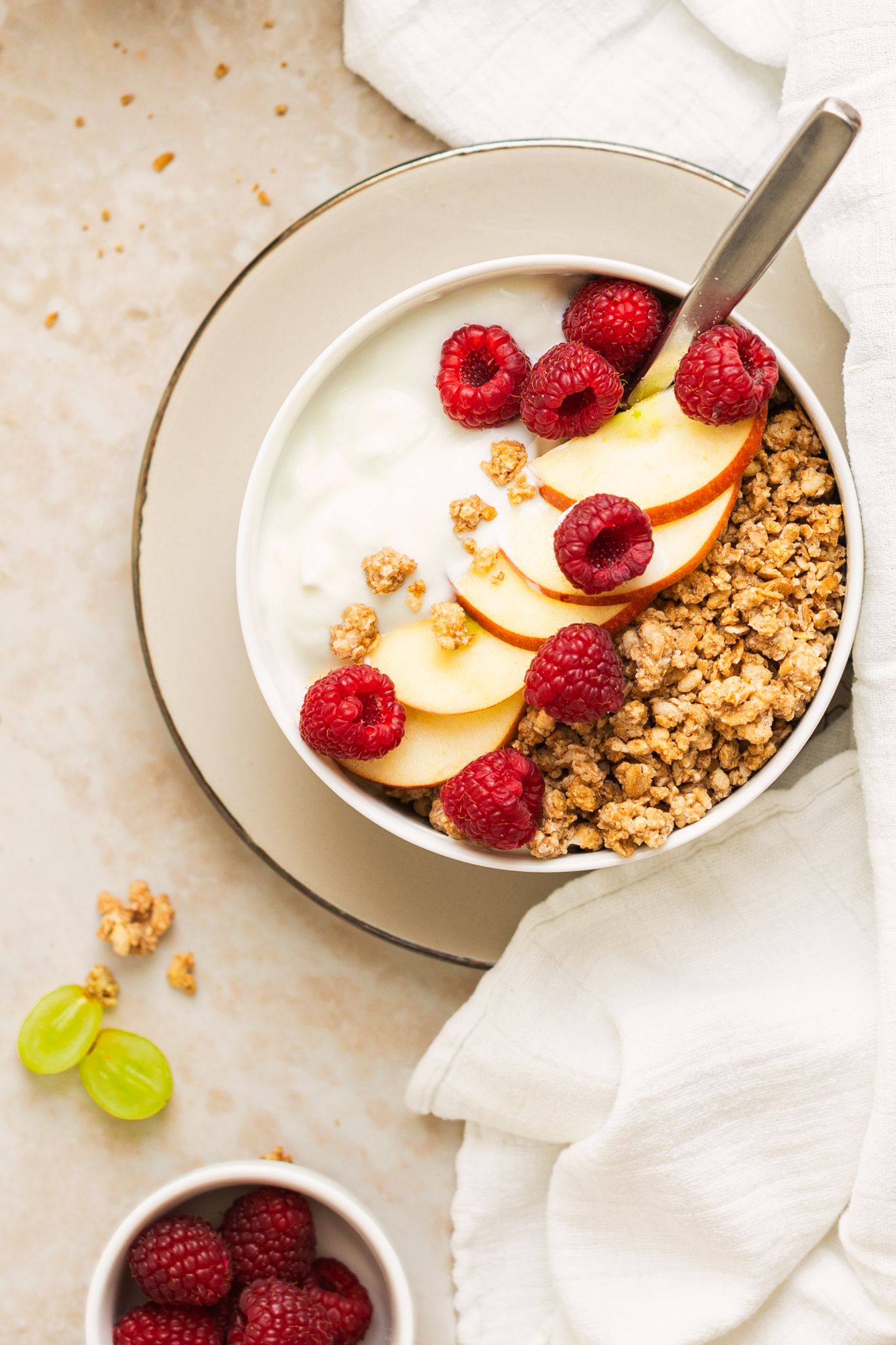 Dieses Foto zeigt eine Müslischale mit einem cremigen Joghurt, knusprigen Müsli und einem Topping aus Apfelscheiben und