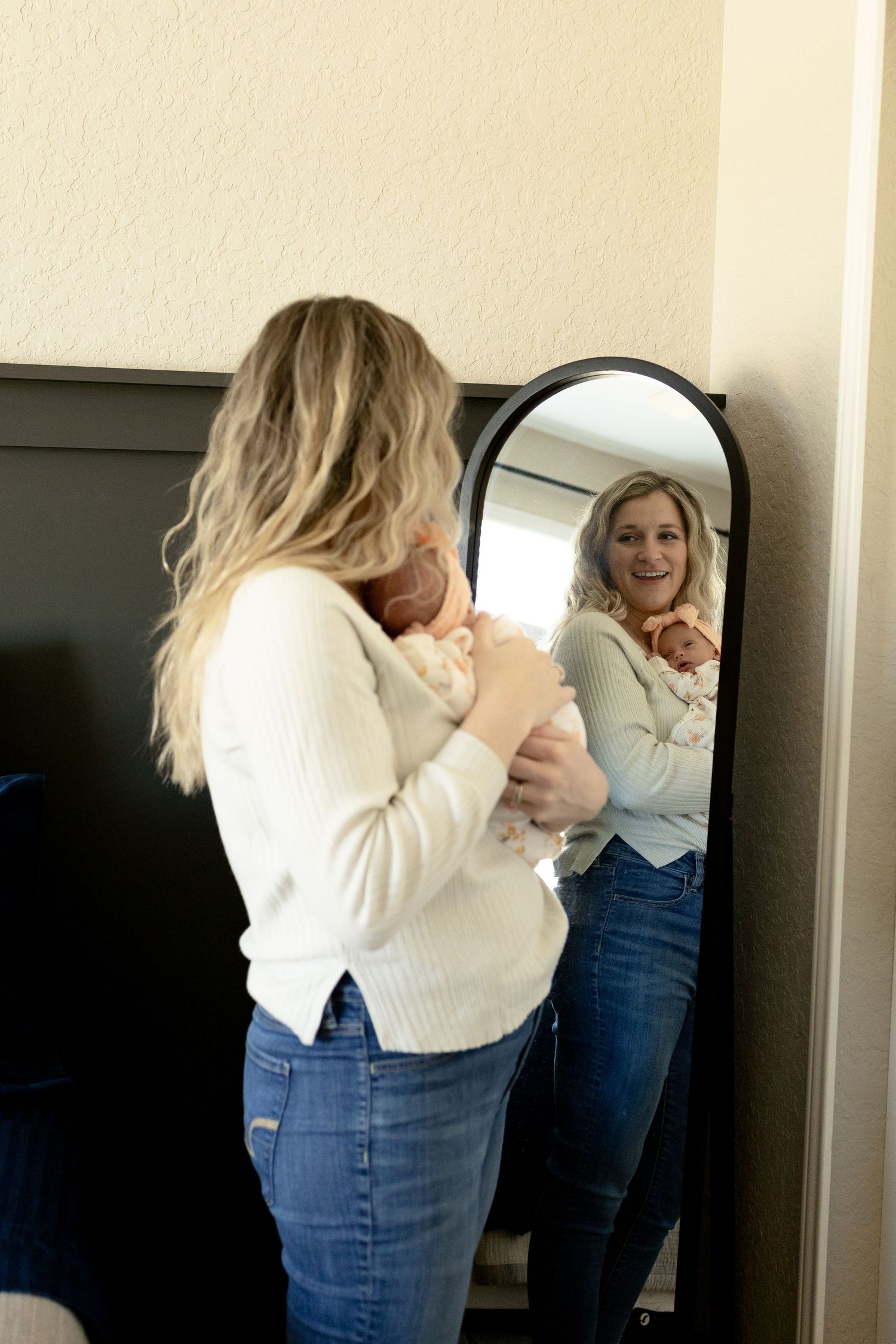 Sequence showing person in white sweater and jeans looking in mirror.