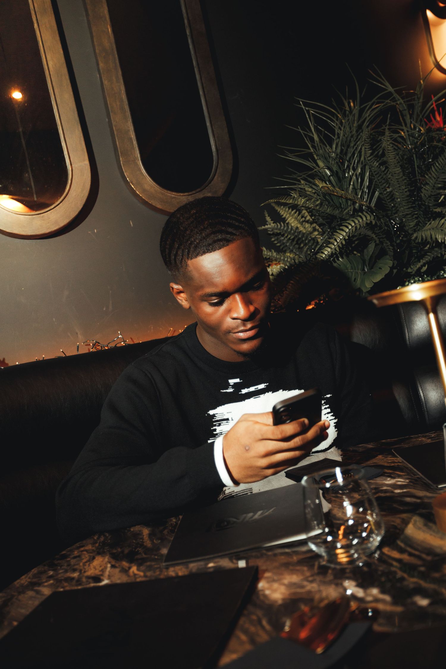 A person in a dark setting examining something closely under dim lighting conditions.