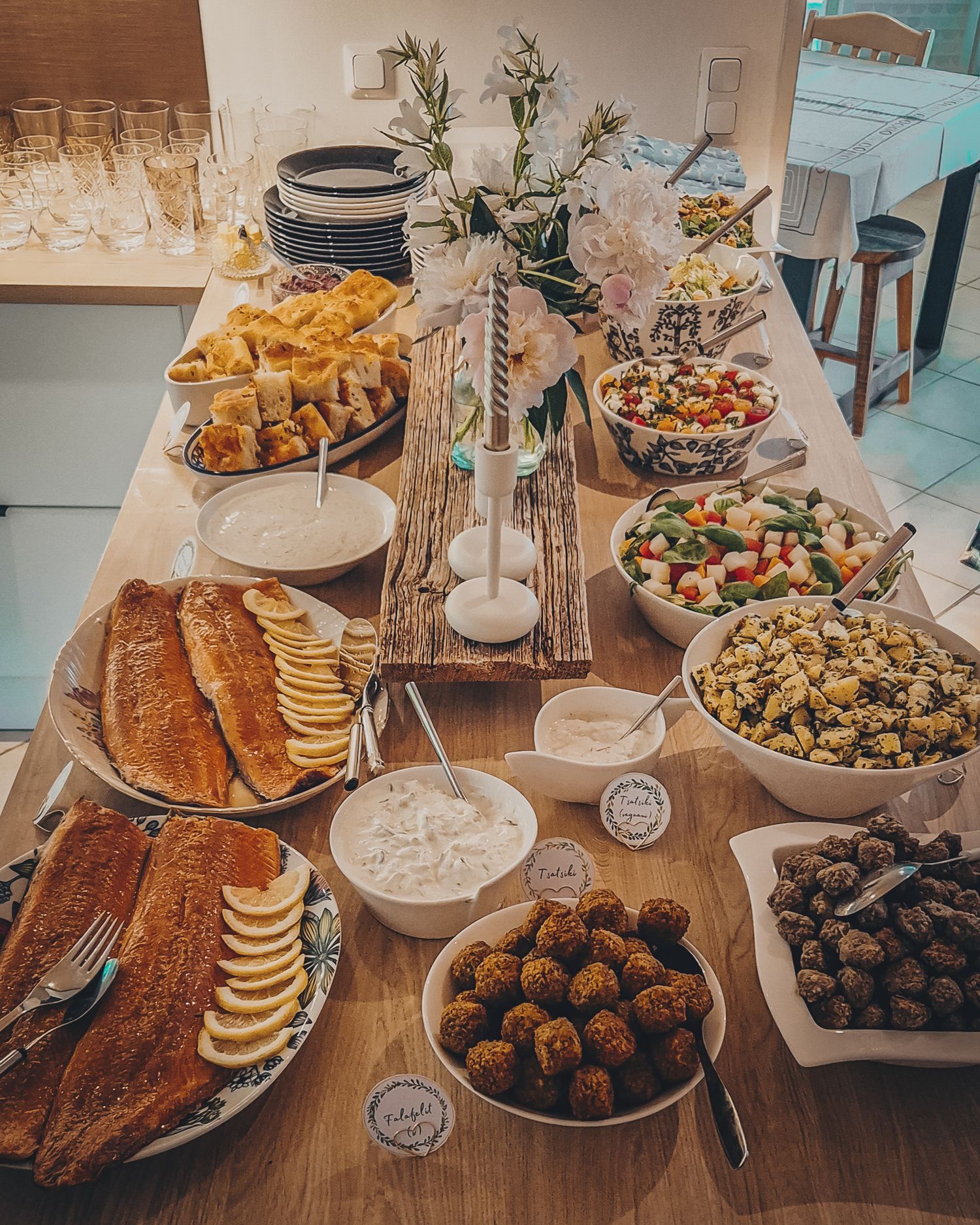Buffet table spread with appetizers, bread, snacks and elegant table settings.