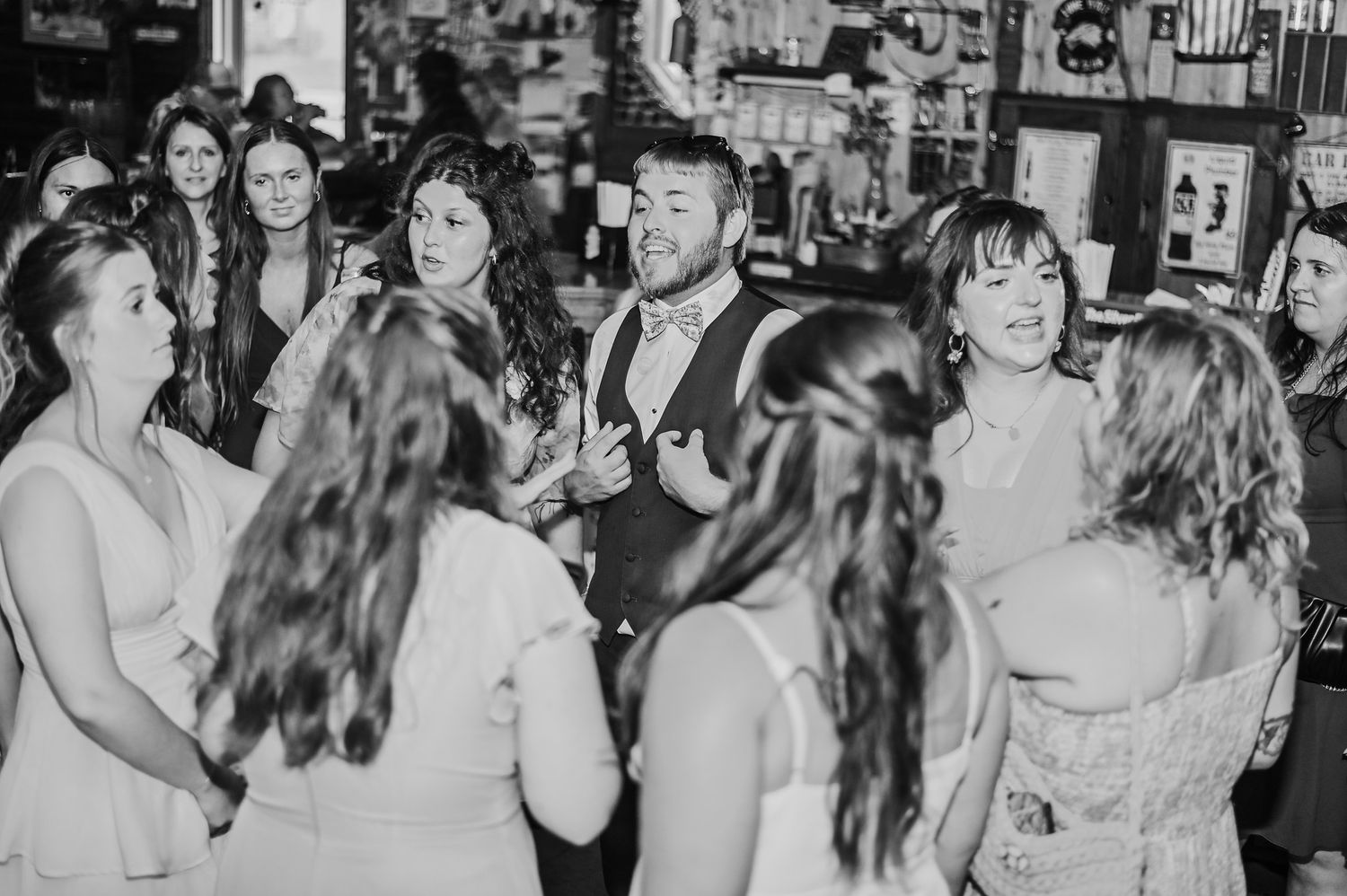 A sequence of black and white photos showing people joyfully dancing and celebrating at what appears to be a wedding reception.