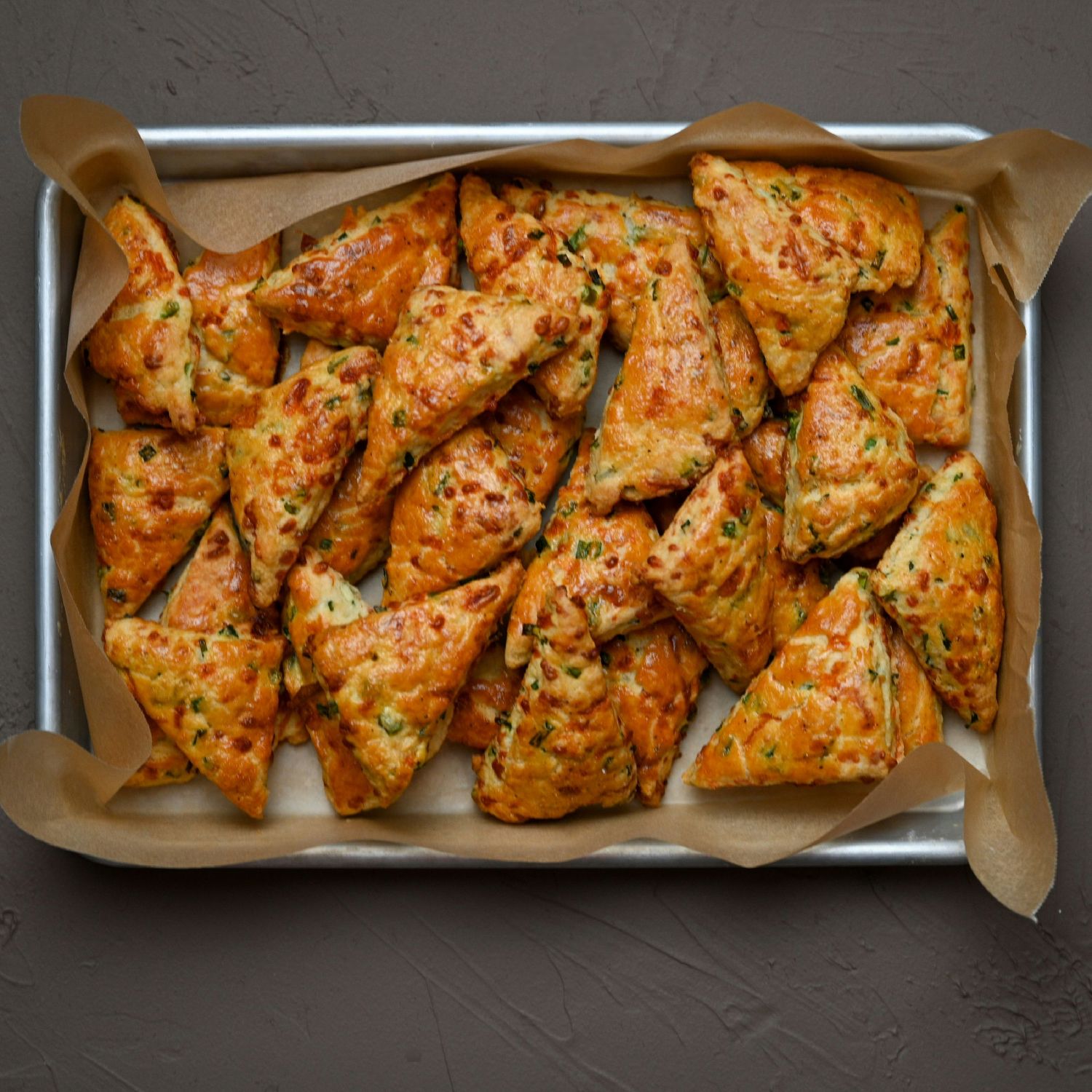 Grilled or roasted chicken pieces seasoned with herbs and spices arranged on a baking sheet with parchment paper.