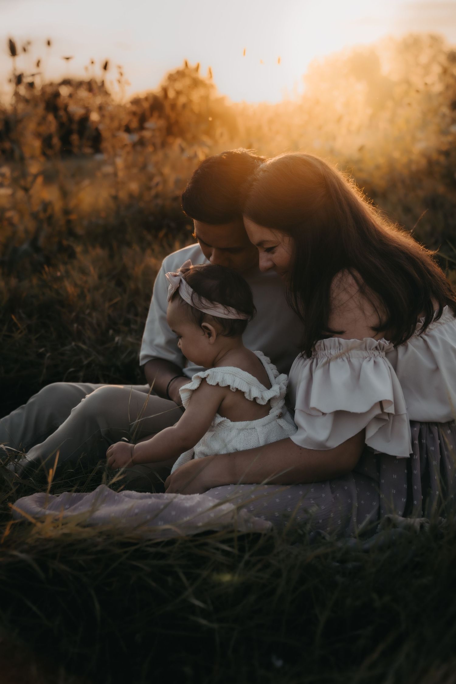 A peaceful family moment in a wildflower field at sunset.