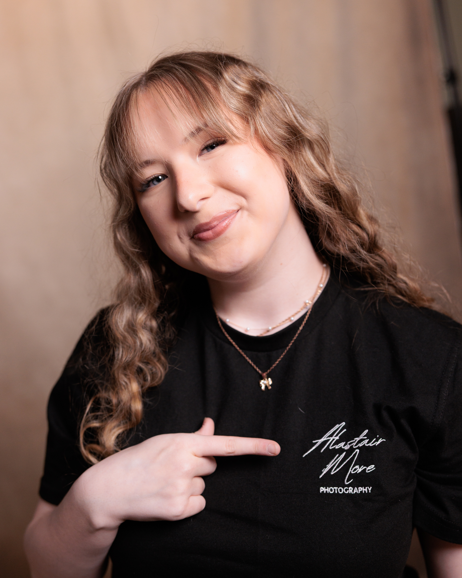 A series of five portraits showing a person in black clothing making playful expressions against a neutral background.