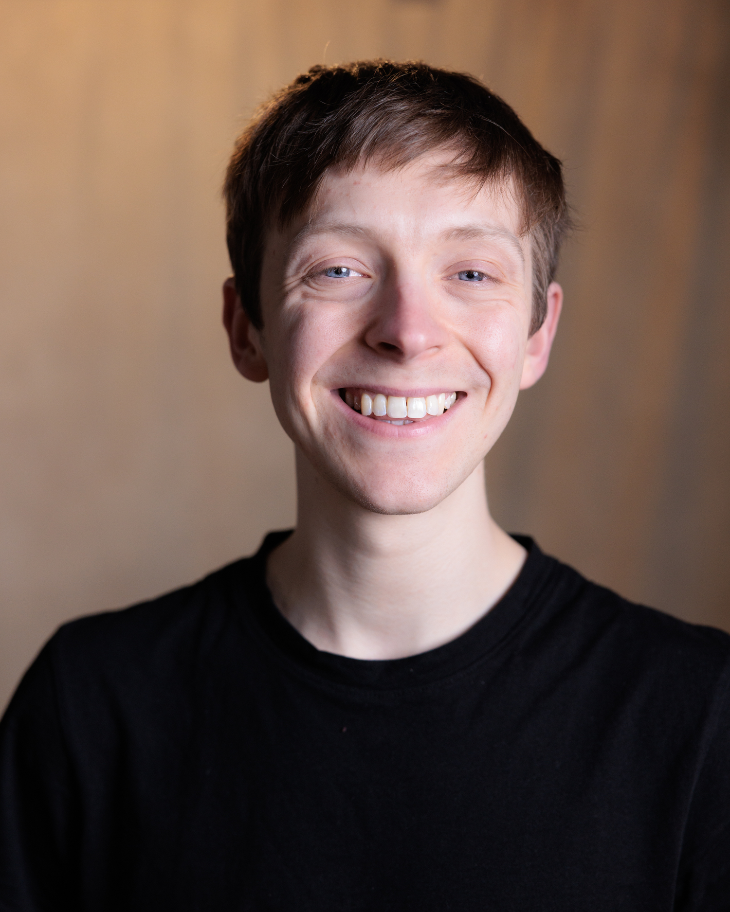 Four headshots showing a smiling person in a black shirt against a neutral background.