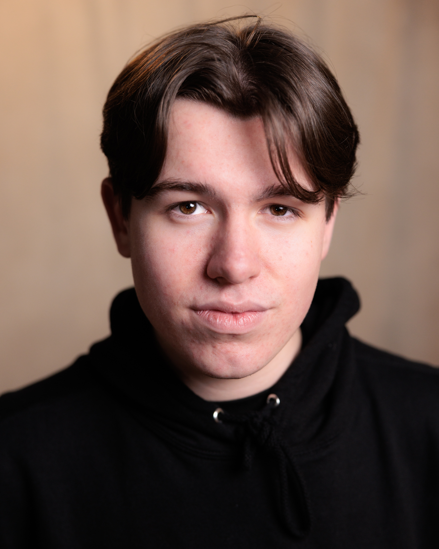 A series of moody portrait photographs showing someone in a black turtleneck against a neutral background.