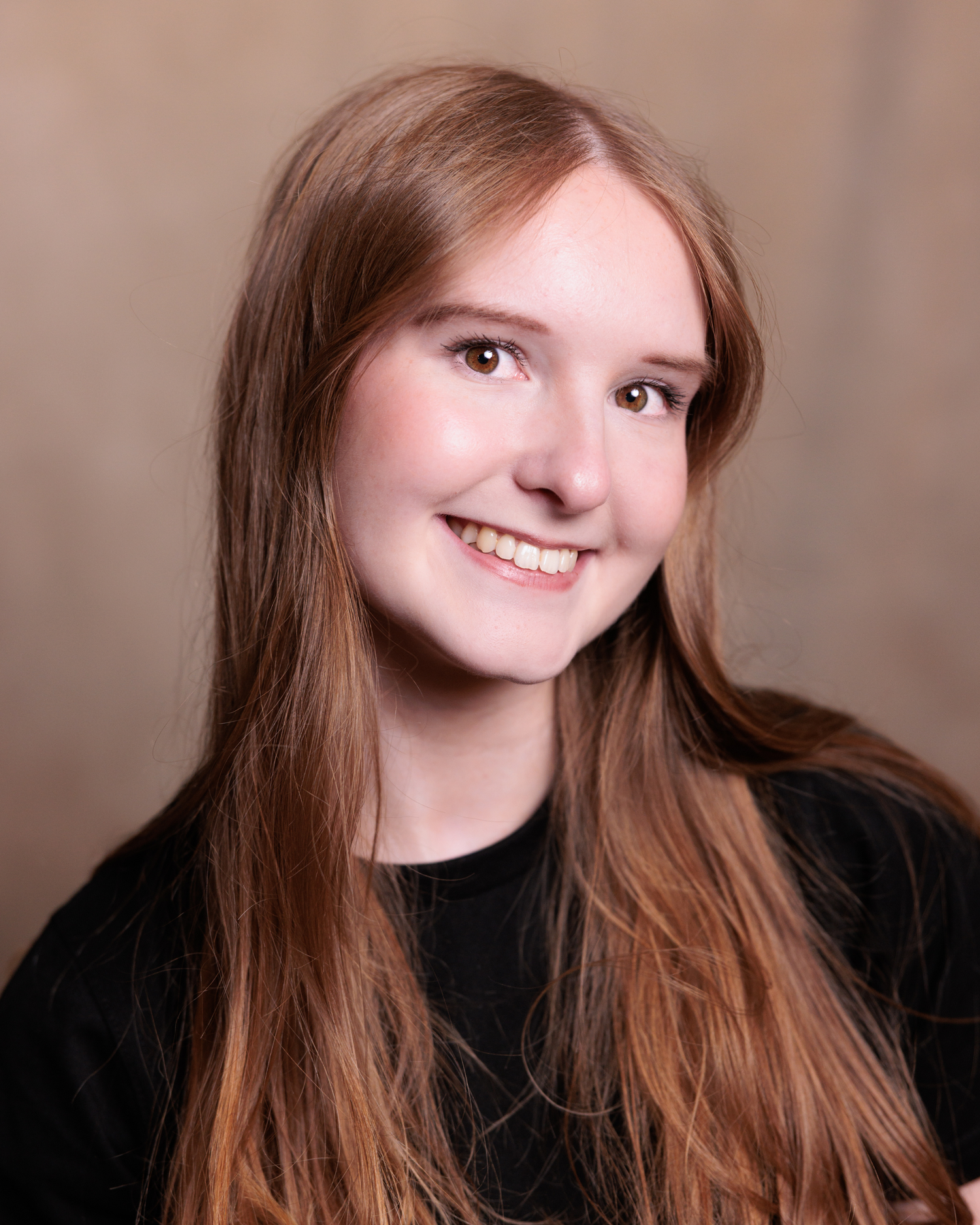 A series of four headshots showing a person with long brown hair and black clothing against a neutral background.